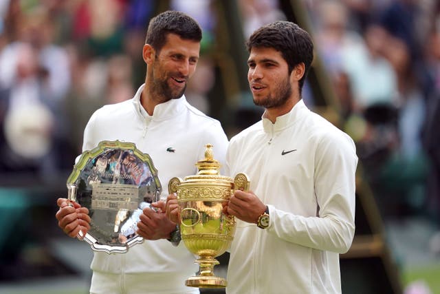 Carlos Alcaraz with the trophy, alongside Novak Djokovic (Victoria Jones/PA)