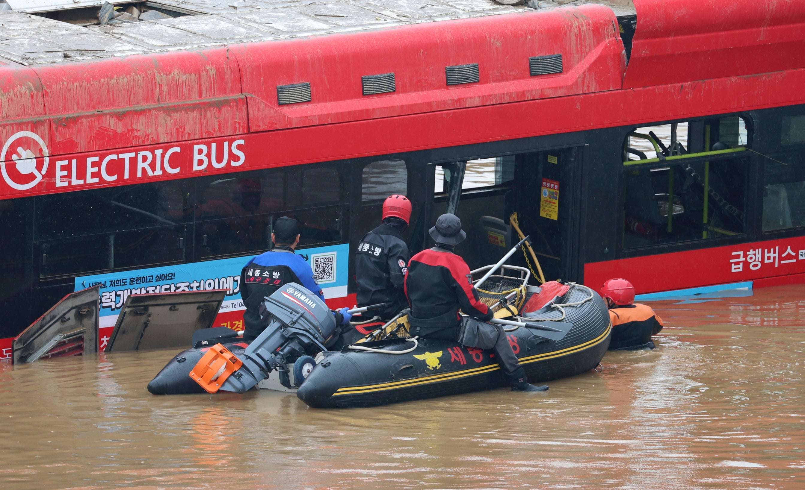 Rescuers conduct a search operation along a road submerged by floodwaters leading to an underground tunnel in Cheongju, South Korea on Sunday, July 16, 2023