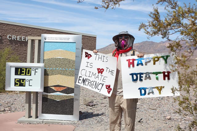 <p>A protestor stands next to a digital display of an unofficial heat reading at Furnace Creek Visitor Center during a heat wave in Death Valley National Park in Death Valley, California, on July 16, 2023</p>
