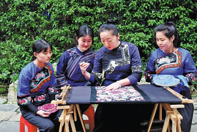 <p>Yi Hua (second from right) demonstrates and explains Miao embroidery to local young women in Xiangxi Tujia and Miao autonomous prefecture, Hunan province</p><p>    </p>