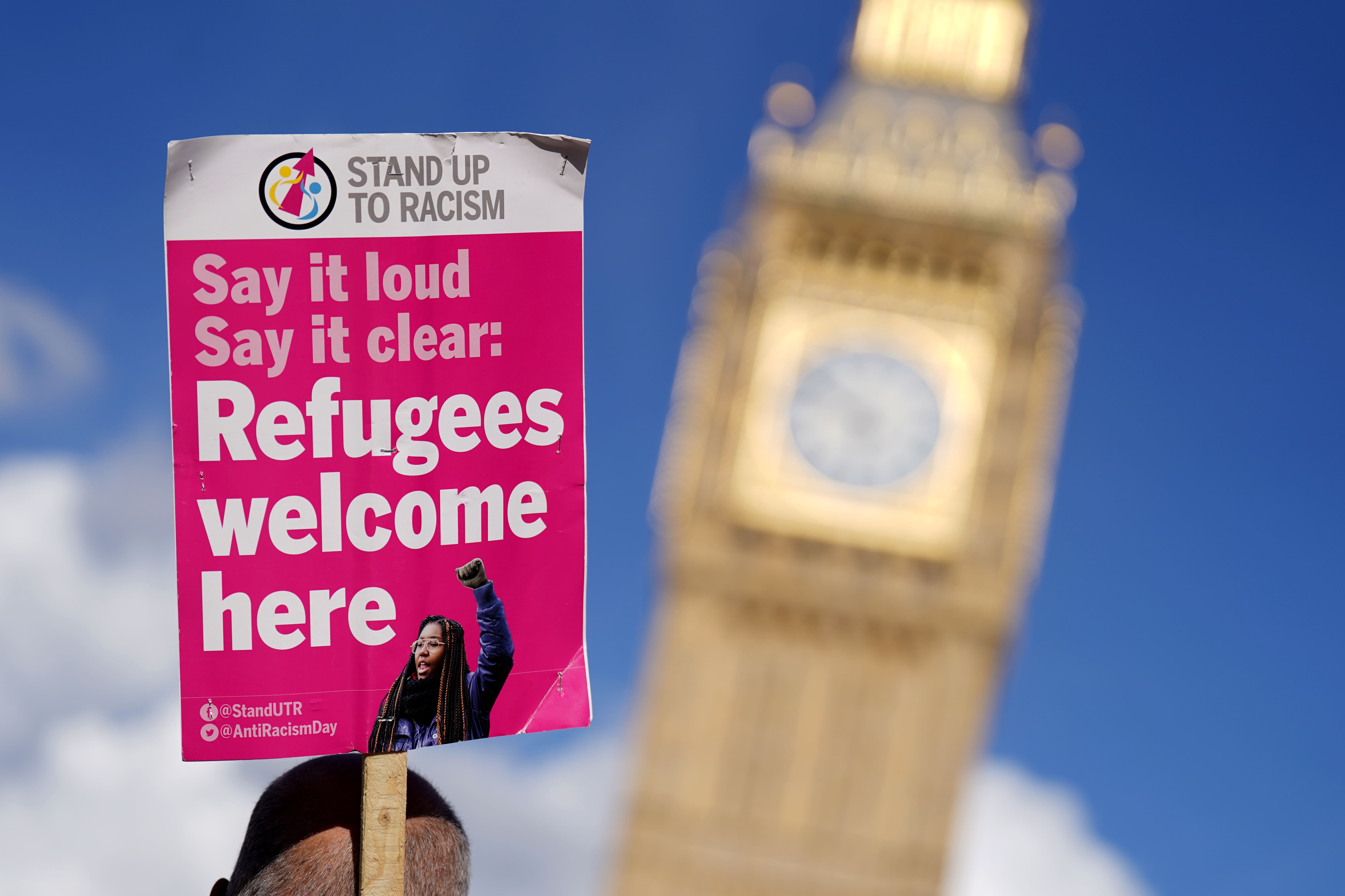 A placard is held aloft at a protest against the Illegal Migration Bill in Parliament Square, Westminster (James Manning/PA)