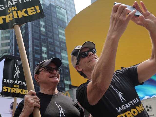 <p>Kevin Bacon (R) and SAG-AFTRA members and supporters protest as the SAG-AFTRA Actors Union Strike continues in front of Paramount Studios at 1515 Broadway on July 17, 2023 in New York City. </p>