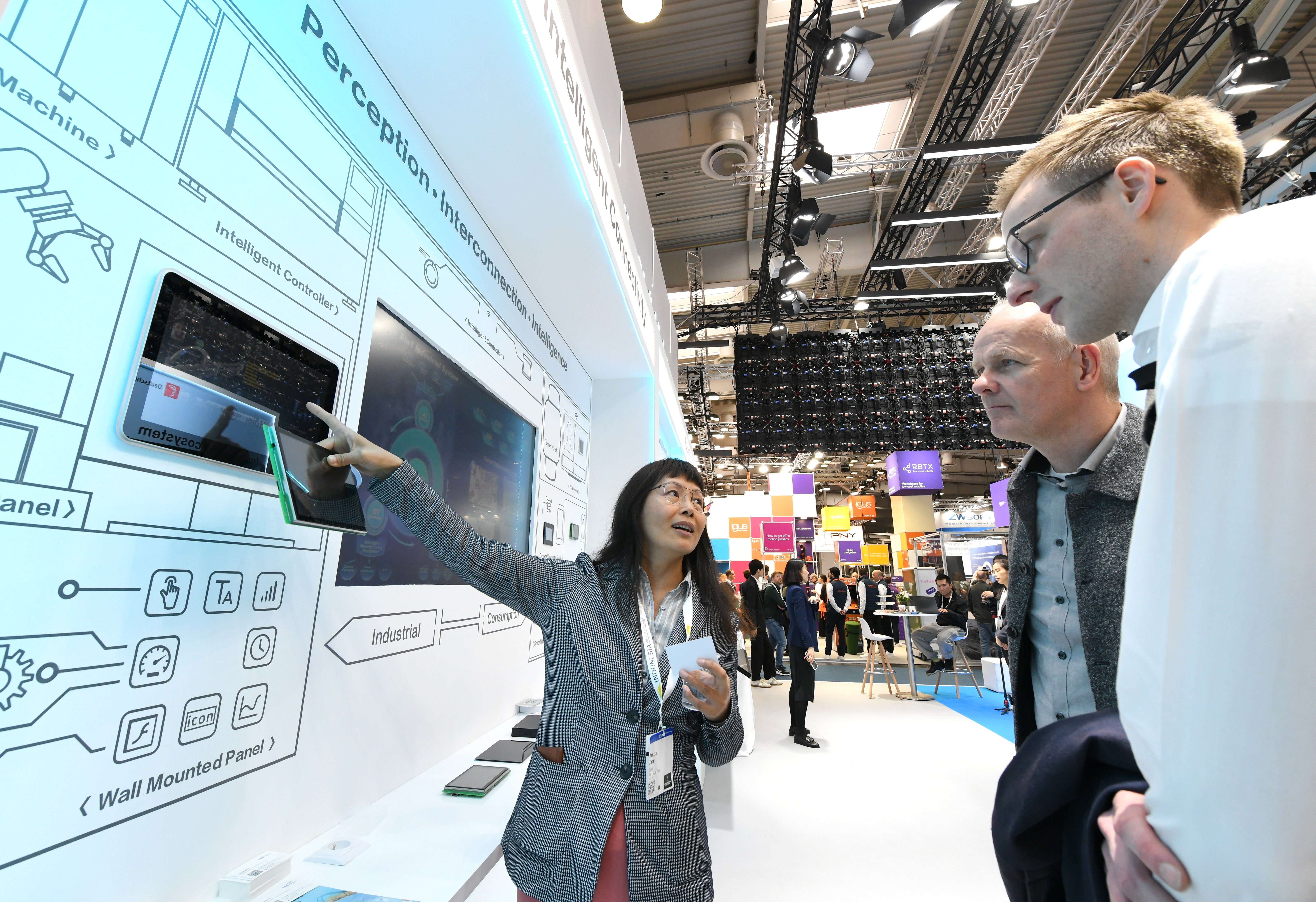 Visitors learn about the intelligent solutions at the booth of COSMOPlat, an industrial internet platform under home appliance manufacturer Haier Group, during the Hannover Messe in Hannover, Germany