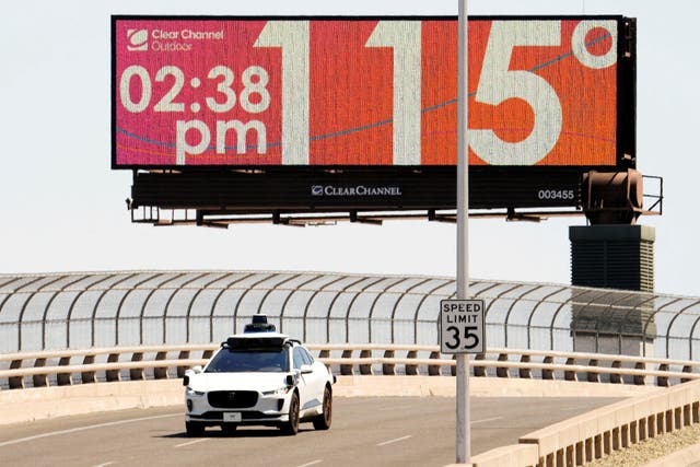 <p>A Waymo self-driving car on Seventh Street as the temperature of 115 degrees is displayed on a digital billboard in downtown Phoenix, Arizona on Monday</p>