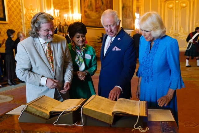The King and Queen are shown a first and second folio of works by William Shakespeare by Gregory Doran, director of the Royal Shakespeare Company, left, and Baroness Vadera, chair of the Royal Shakespeare Company, during a reception at Windsor Castle (Andrew Matthews/PA)