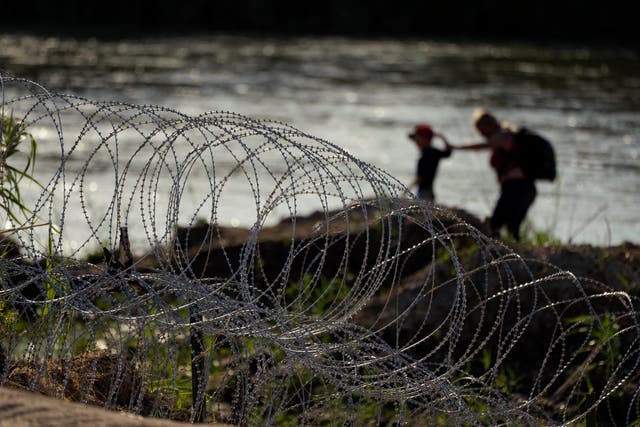 <p>Migrants walk along concertina wire as they try to cross the Rio Grande at the Texas-U.S. border in Eagle Pass, Texas, Thursday, July 6, 2023.</p>