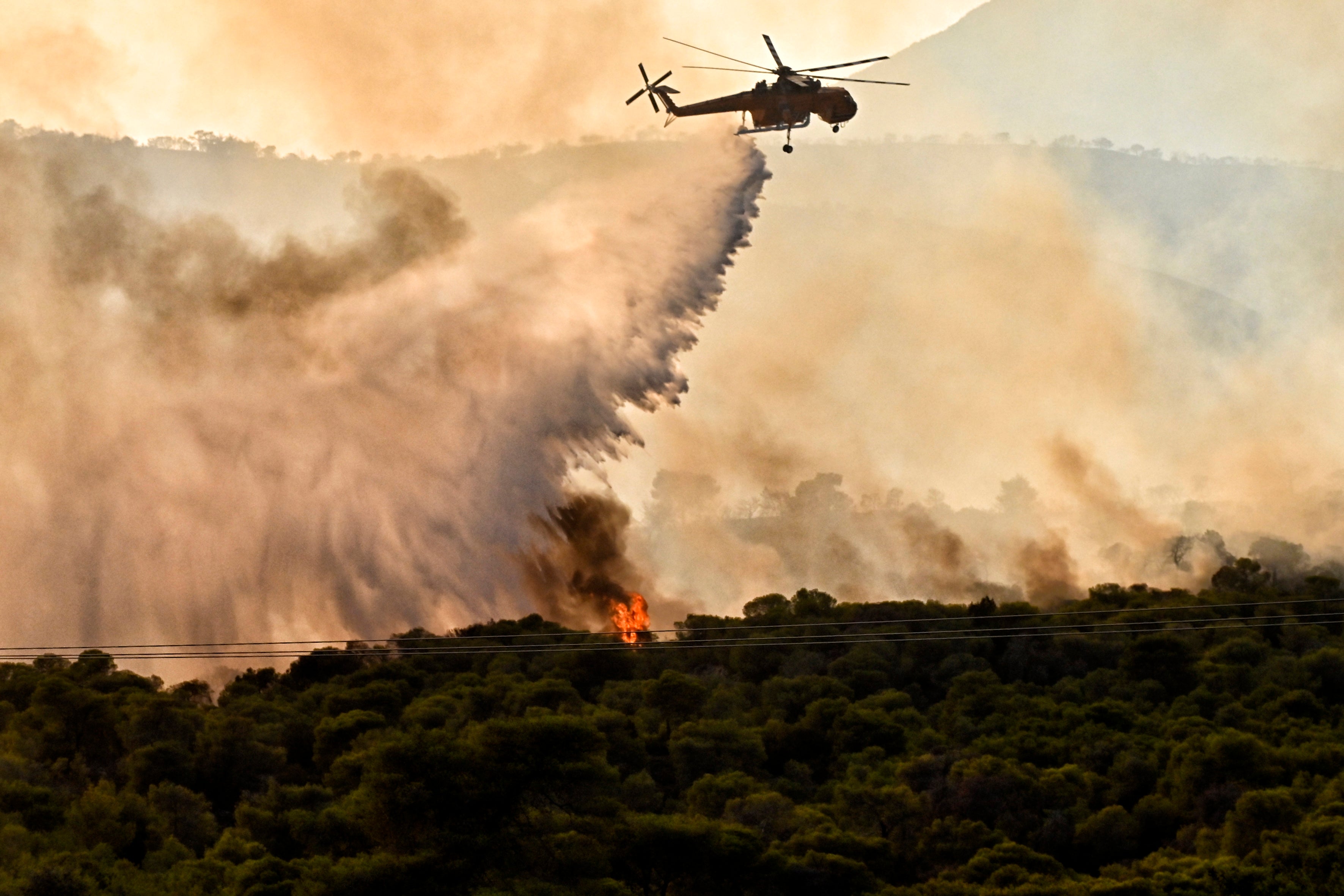 A firefighting aircraft drops water to extinguish a wildfire at Aghios Charalambos area in Loutraki, Corinth, Greece