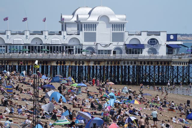 People enjoy the warm weather on Southsea beach (Andrew Matthews/PA)