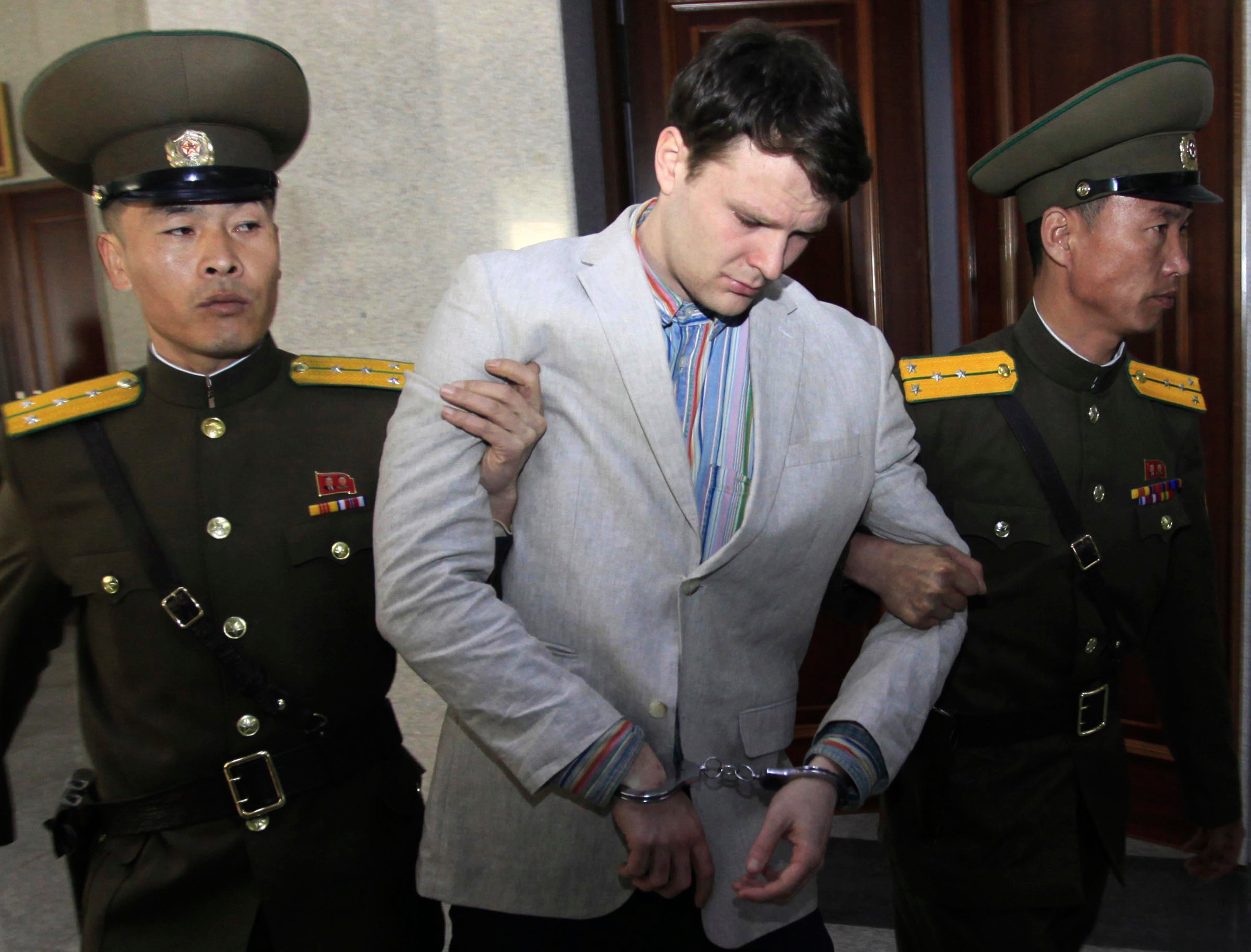 American student Otto Warmbier (centre) escorted at the Supreme Court in Pyongyang, North Korea on 16 March 2016