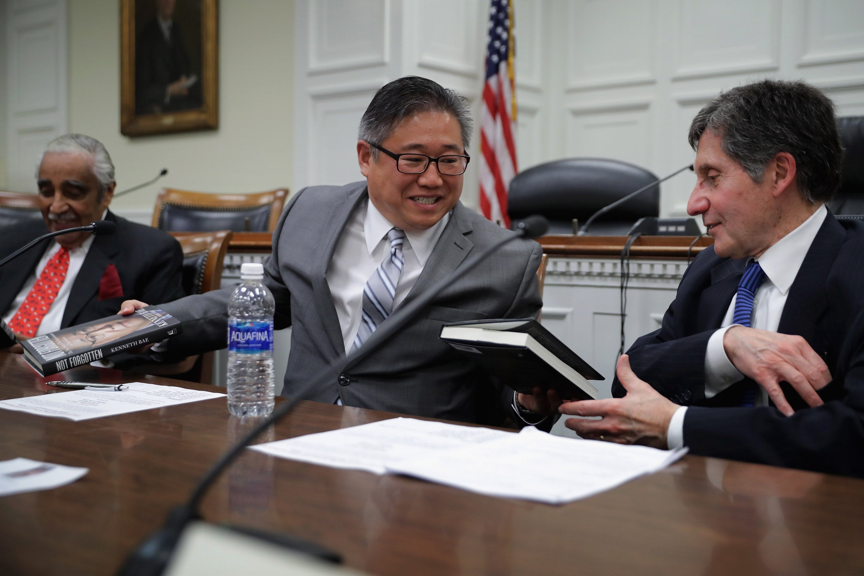 Kenneth Bae (centre) gives copies of his new book ‘Not Forgotten’, to representative Charles Rangel (left) and Ambassador Joseph DeTrani (right)