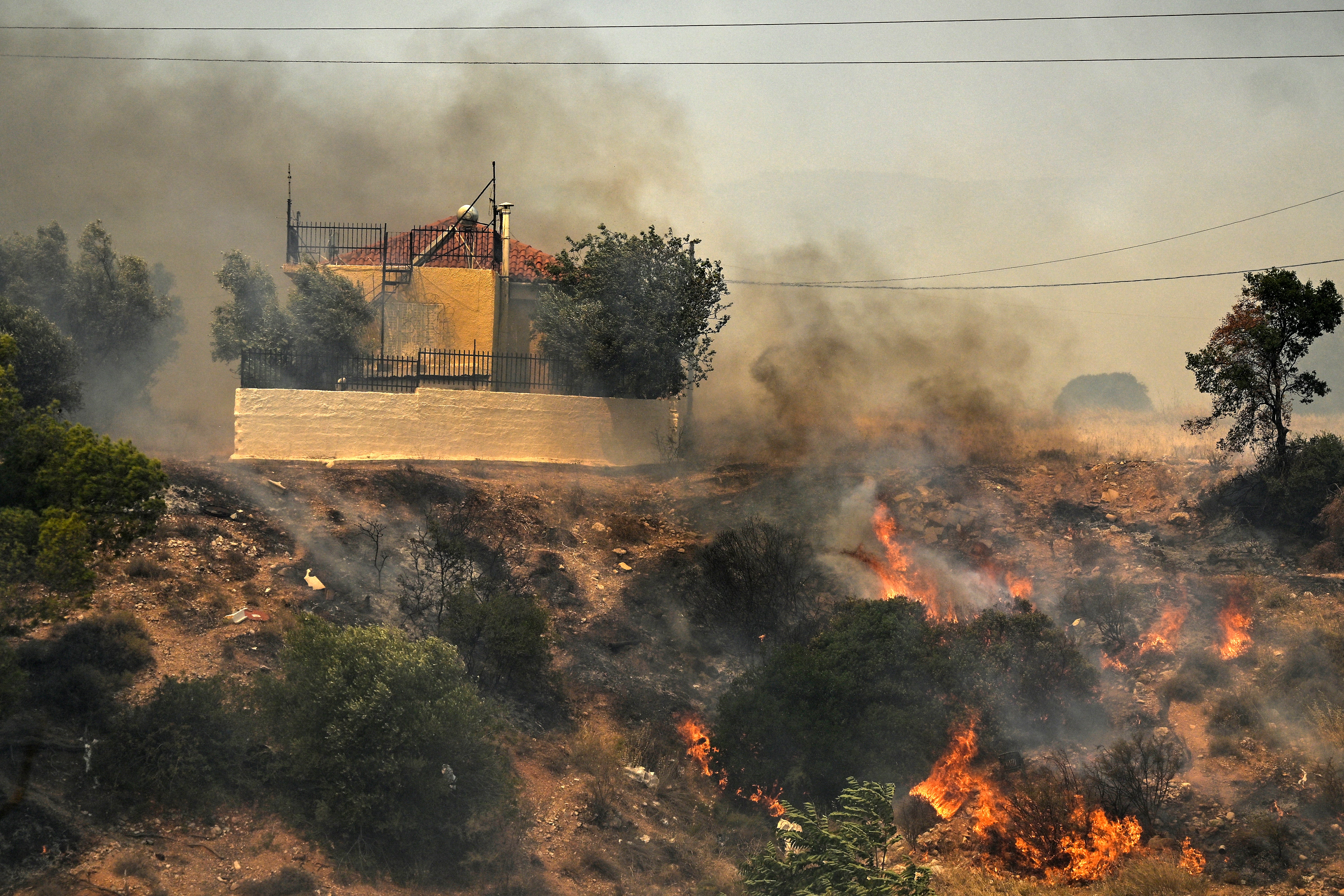 House threatened by a fire at the settlement of Kandyli, near Athens