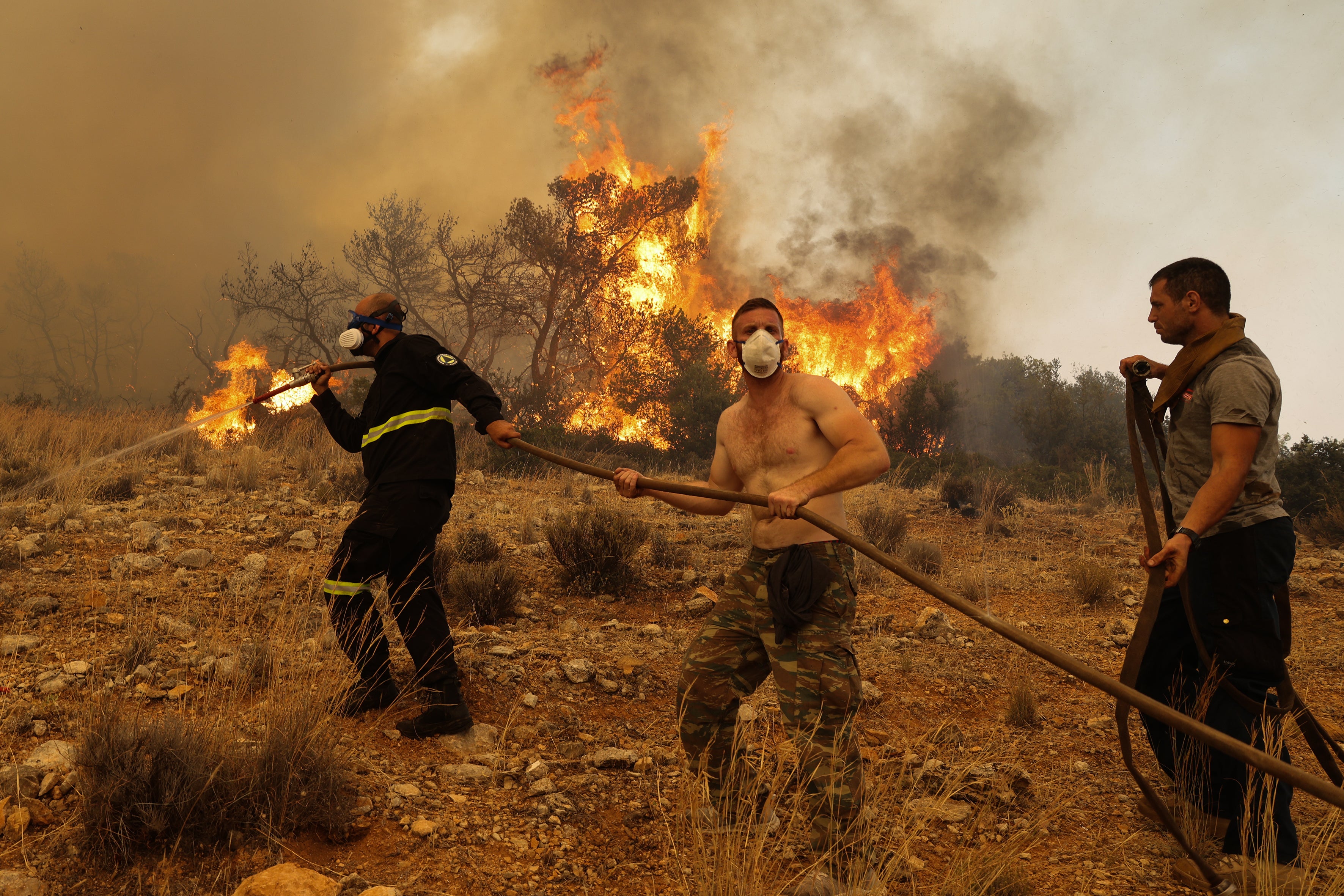 Firefighter teams intervene a wildfire at the village of Ano Vlichada, near Athens