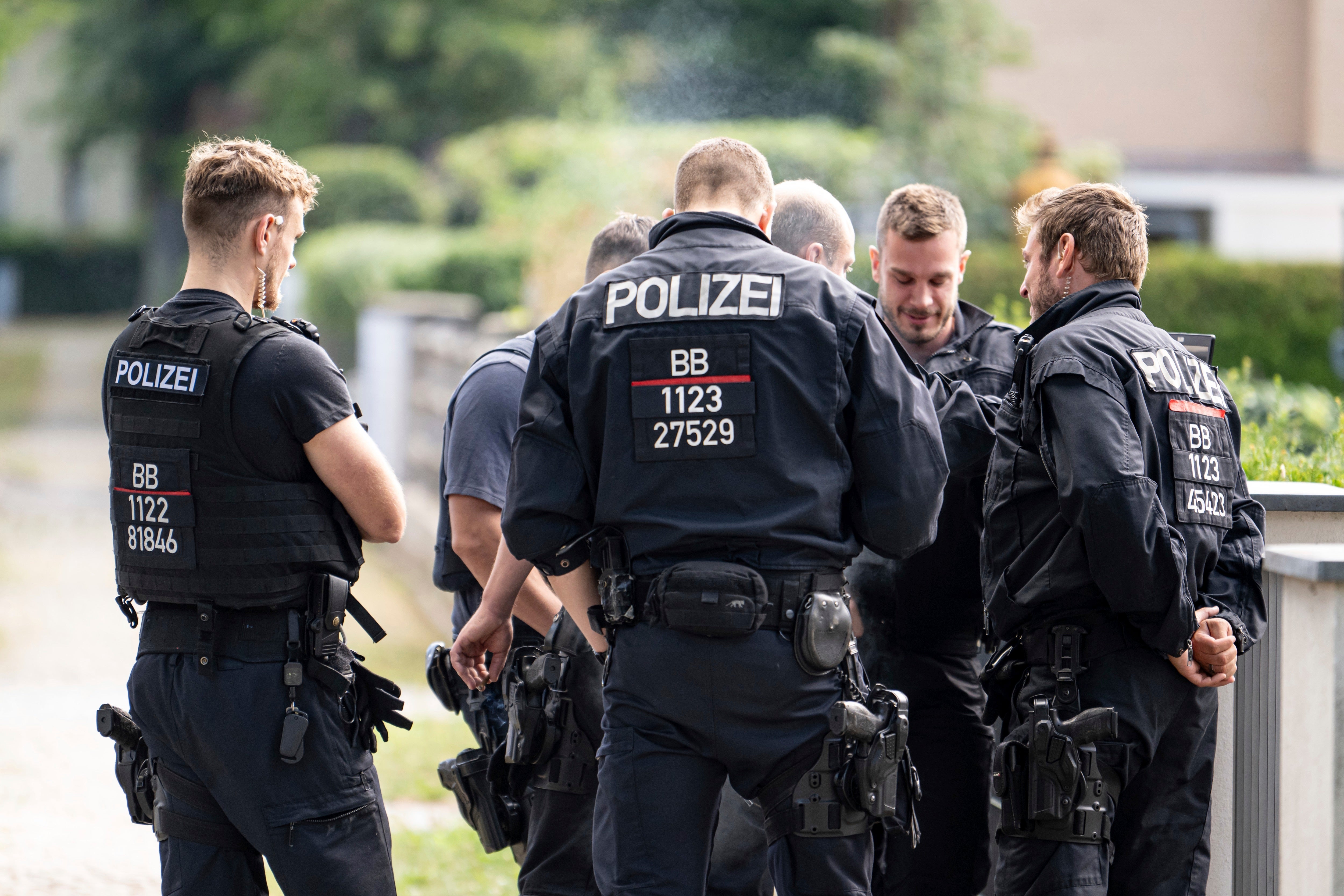 Police officers coordinate the search for a wild animal in a residential area in Teltow, Germany