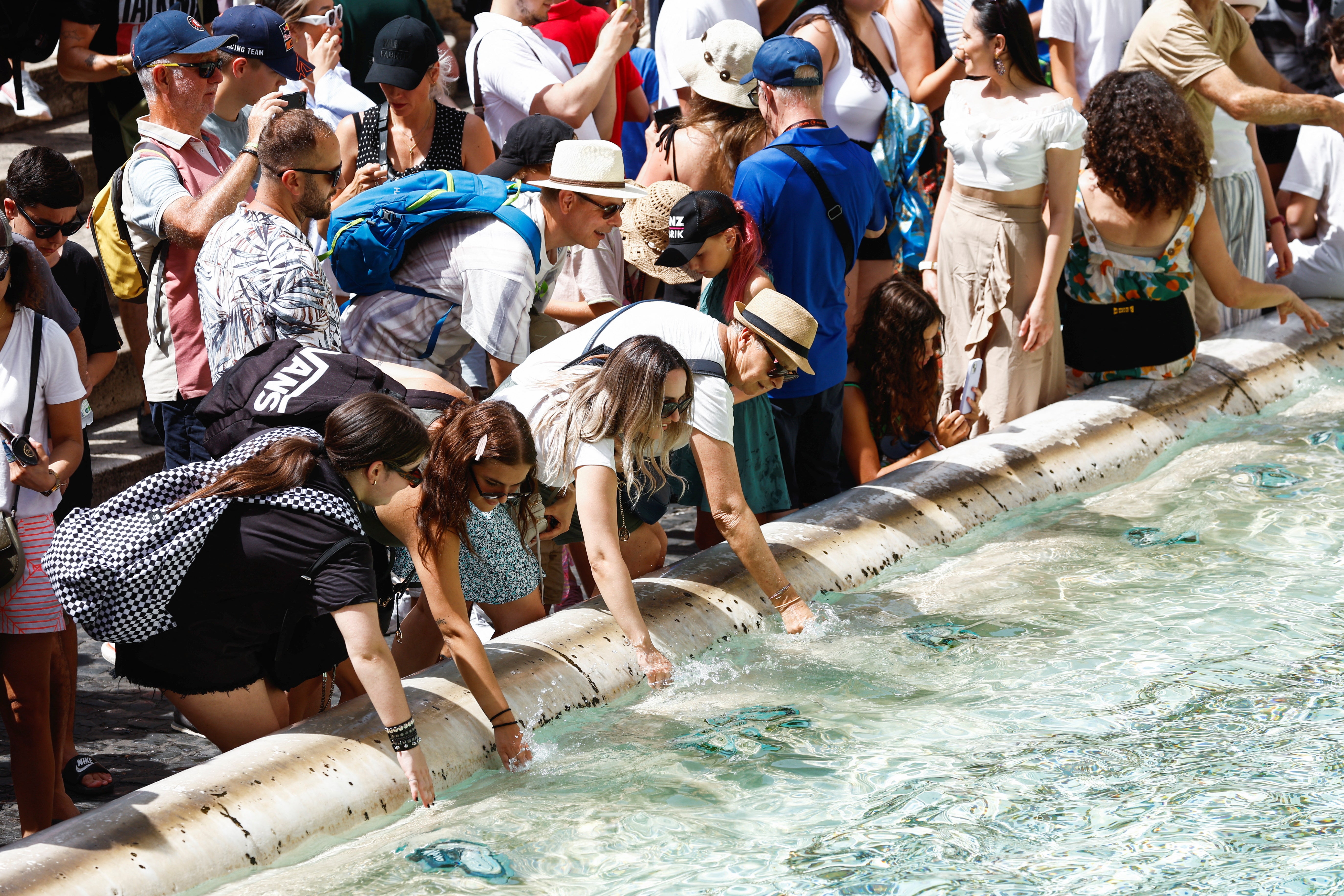 People cool themselves at the Trevi Fountain during a heatwave across Italy