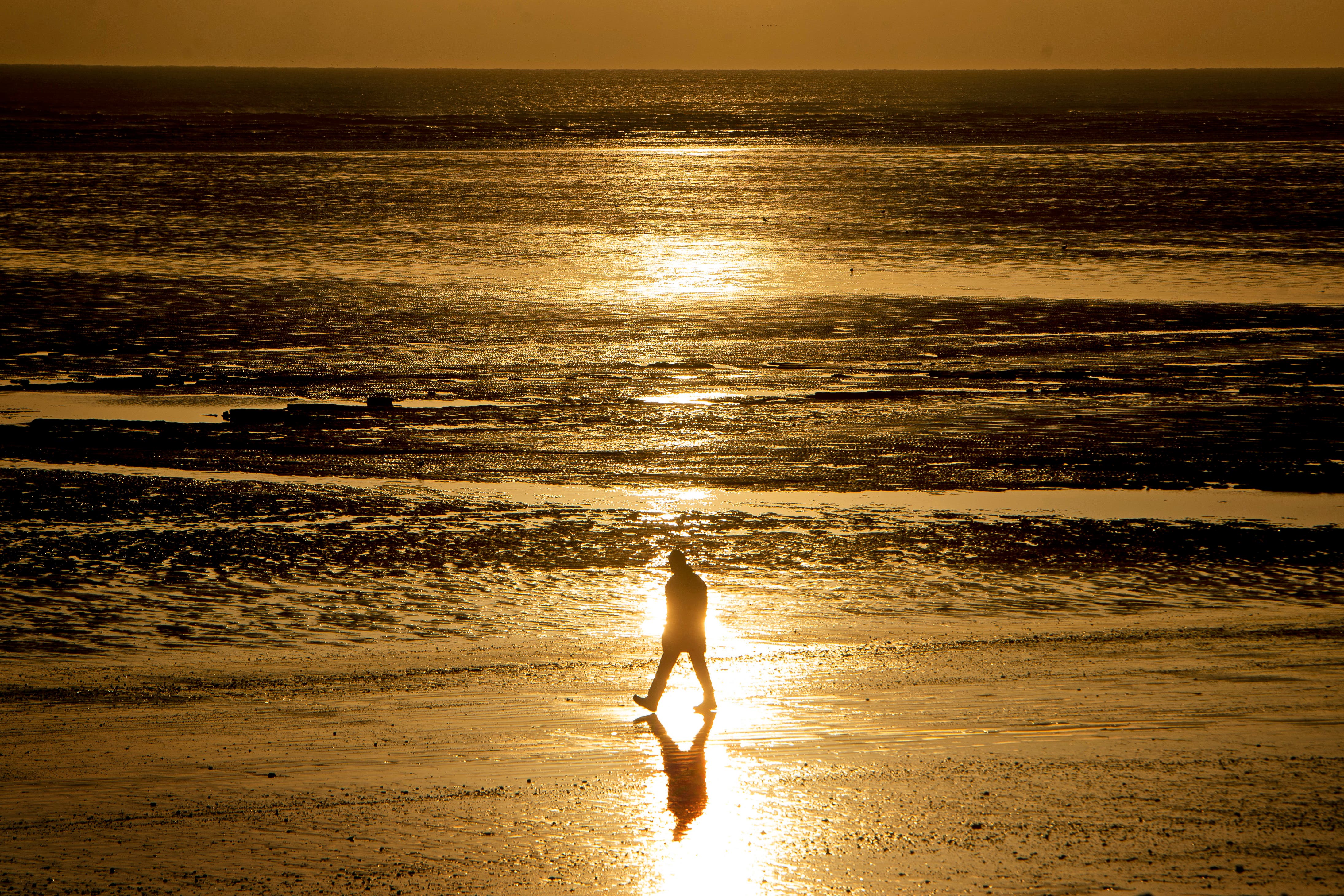 A walker on a beach in Kent (Victoria Jones/PA)