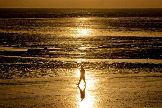 A walker on a beach in Kent (Victoria Jones/PA)