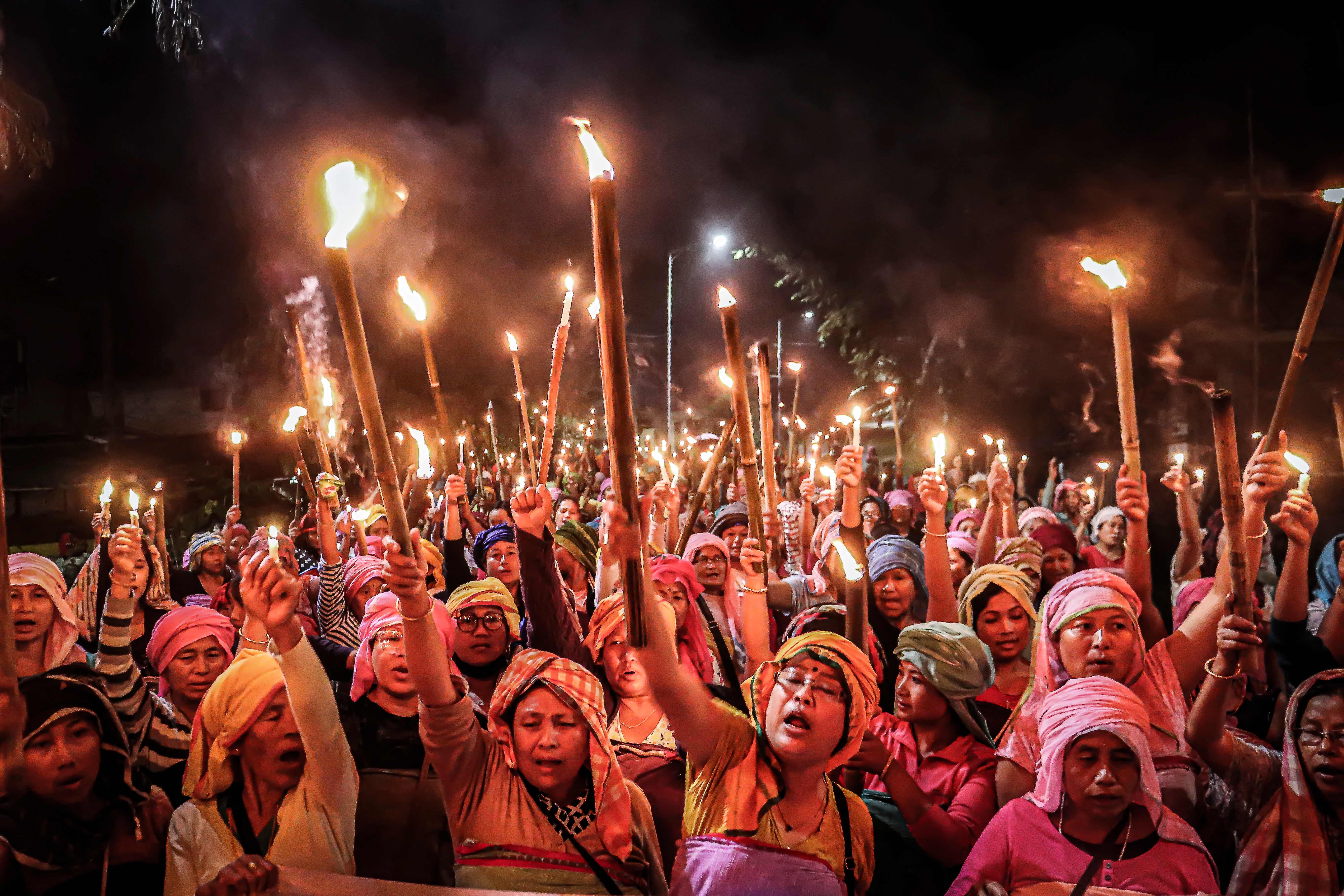 Women belonging to the ‘Meira Paibis’, a group of women representing Meitei society, hold torches during a demonstration demanding the restoration of peace in India’s northeastern Manipur state in Imphal