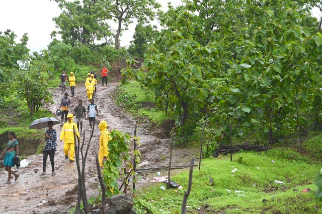 <p>Rescue workers walk down a mud track leading up to the site of a landslide at Irshalwadi village in Raigad district of India’s Maharashtra state on 20 July 2023</p>