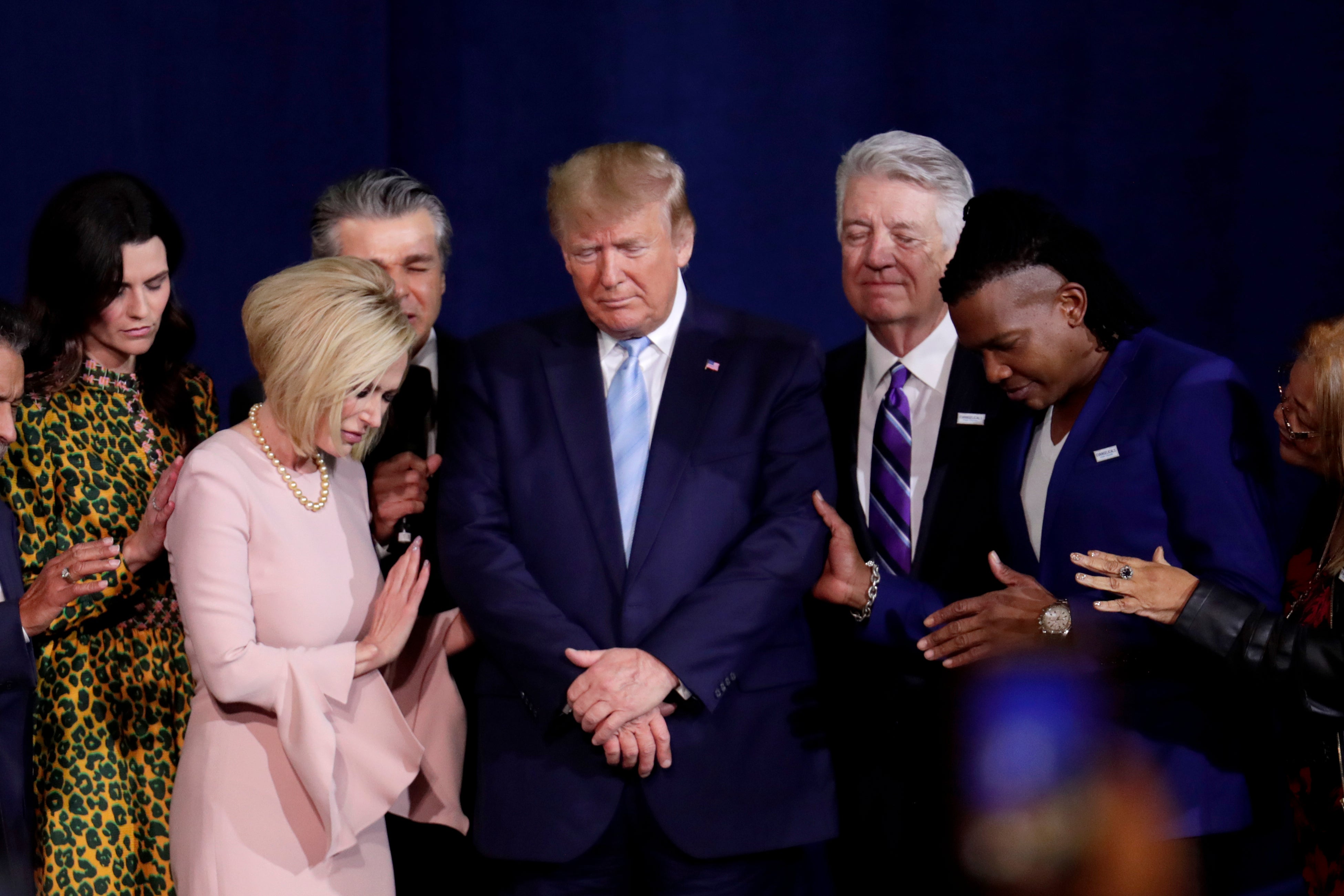 Pastor Paula White, left, and other faith leaders pray with President Donald Trump, center, during a rally for evangelical supporters at the King Jesus International Ministry church, Friday, Jan. 3, 2020