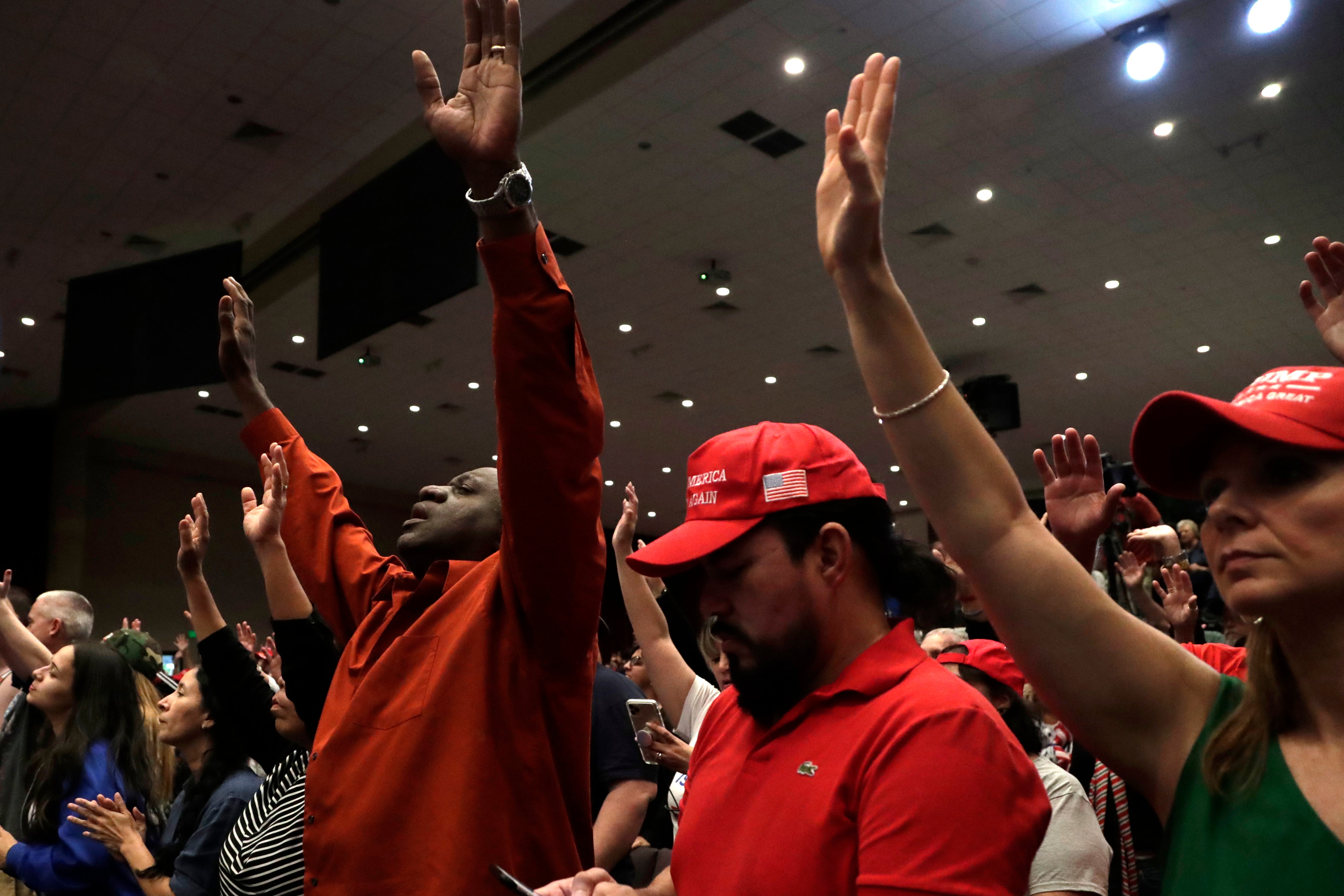 People raise their arms in prayer during a rally for evangelical supporters of President Donald Trump at the King Jesus International Ministry church, Friday, Jan. 3, 2020, in Miami.