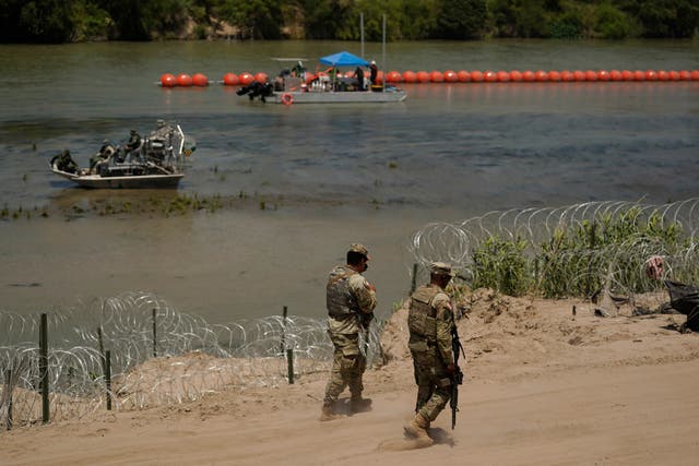 <p>Guardsmen patrol as workers continue to deploy large buoys to be used as a border barrier along the banks of the Rio Grande in Eagle Pass, Texas, Wednesday, July 12, 2023</p>