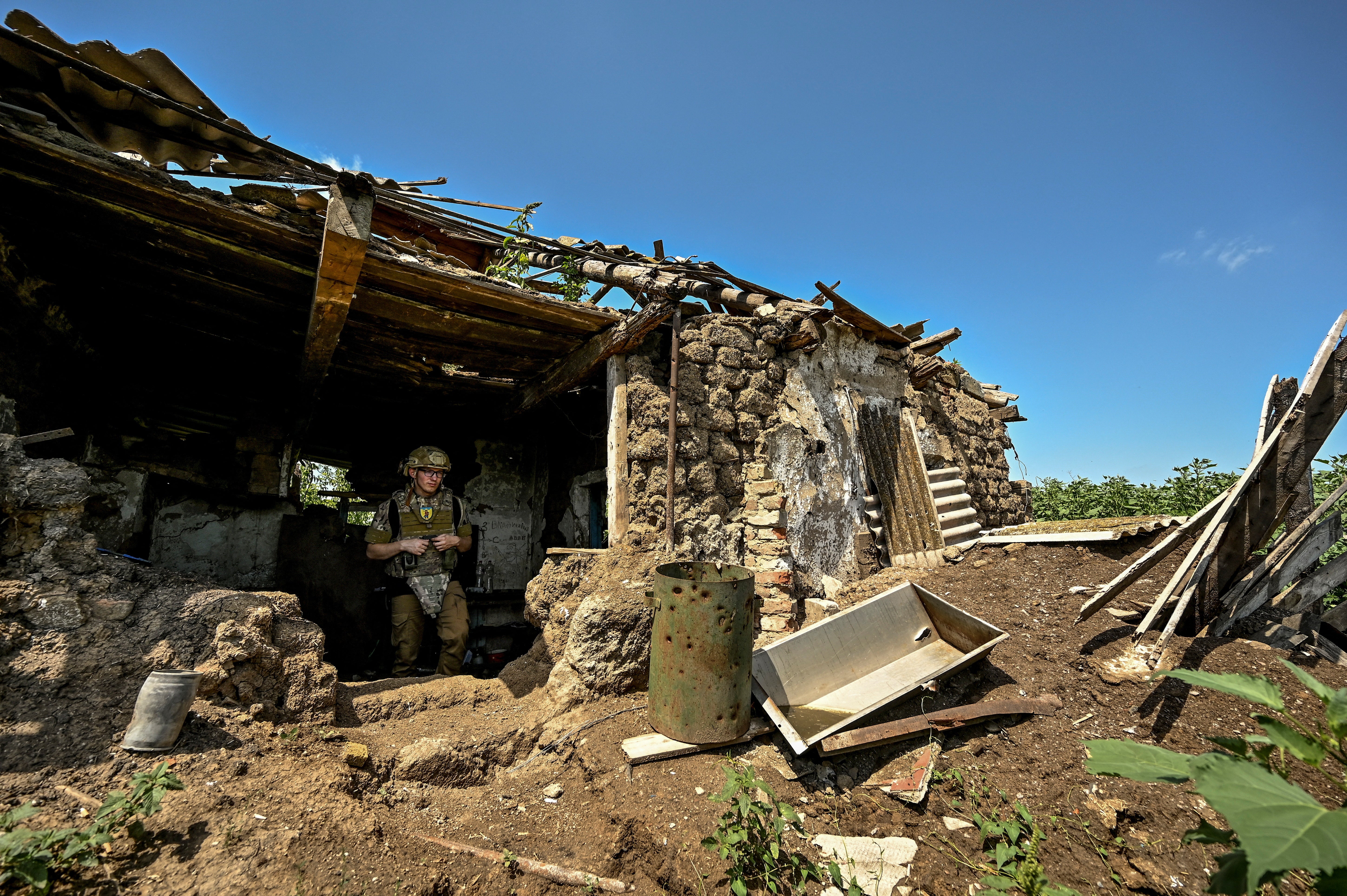 Ukrainian serviceman inspects a former position of Russian troops in the recently liberated village of Novodarivka