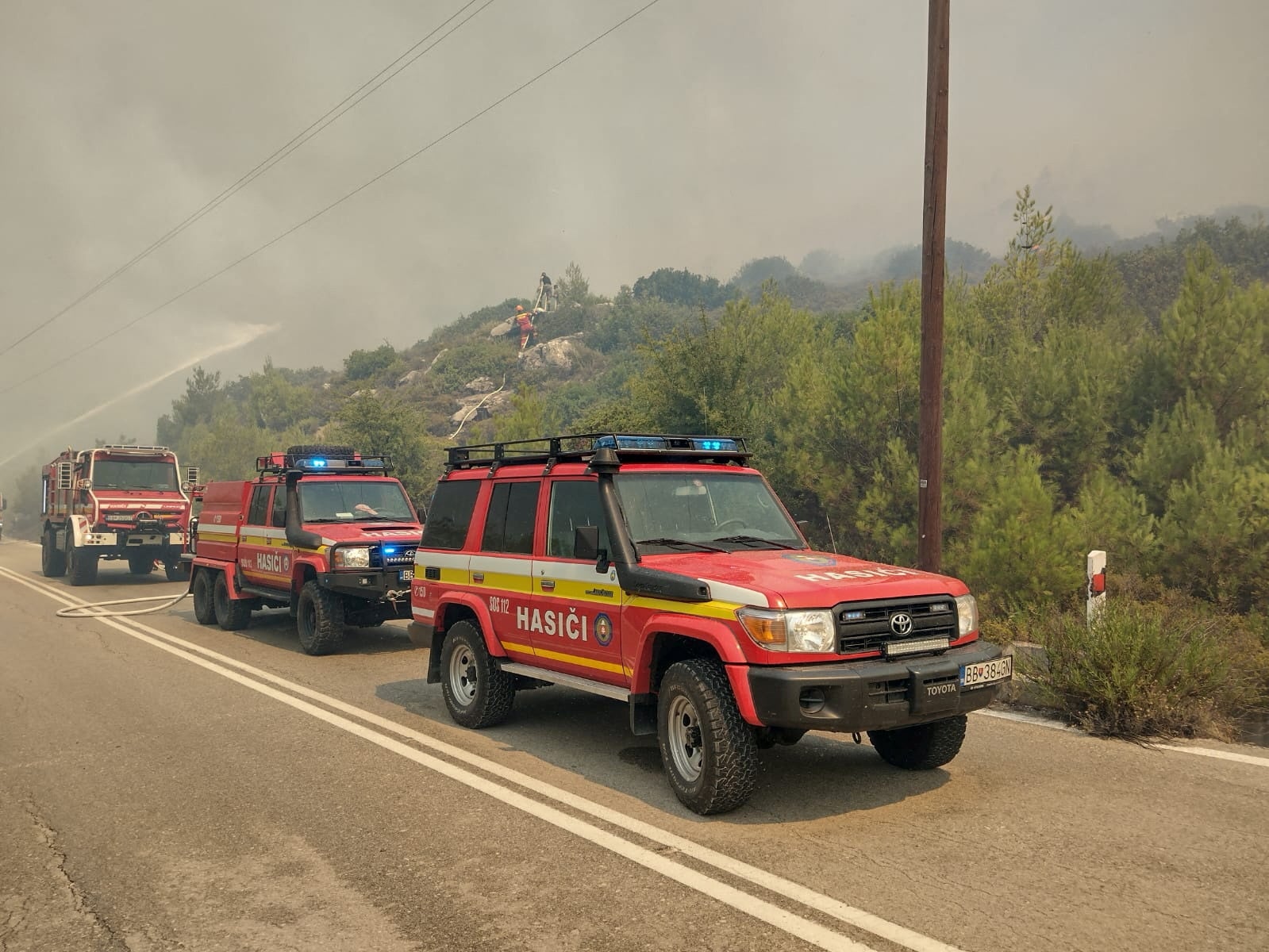 Firetrucks line up as firefighters try to extinguish a wildfire burning on Rhodes Island, Greece