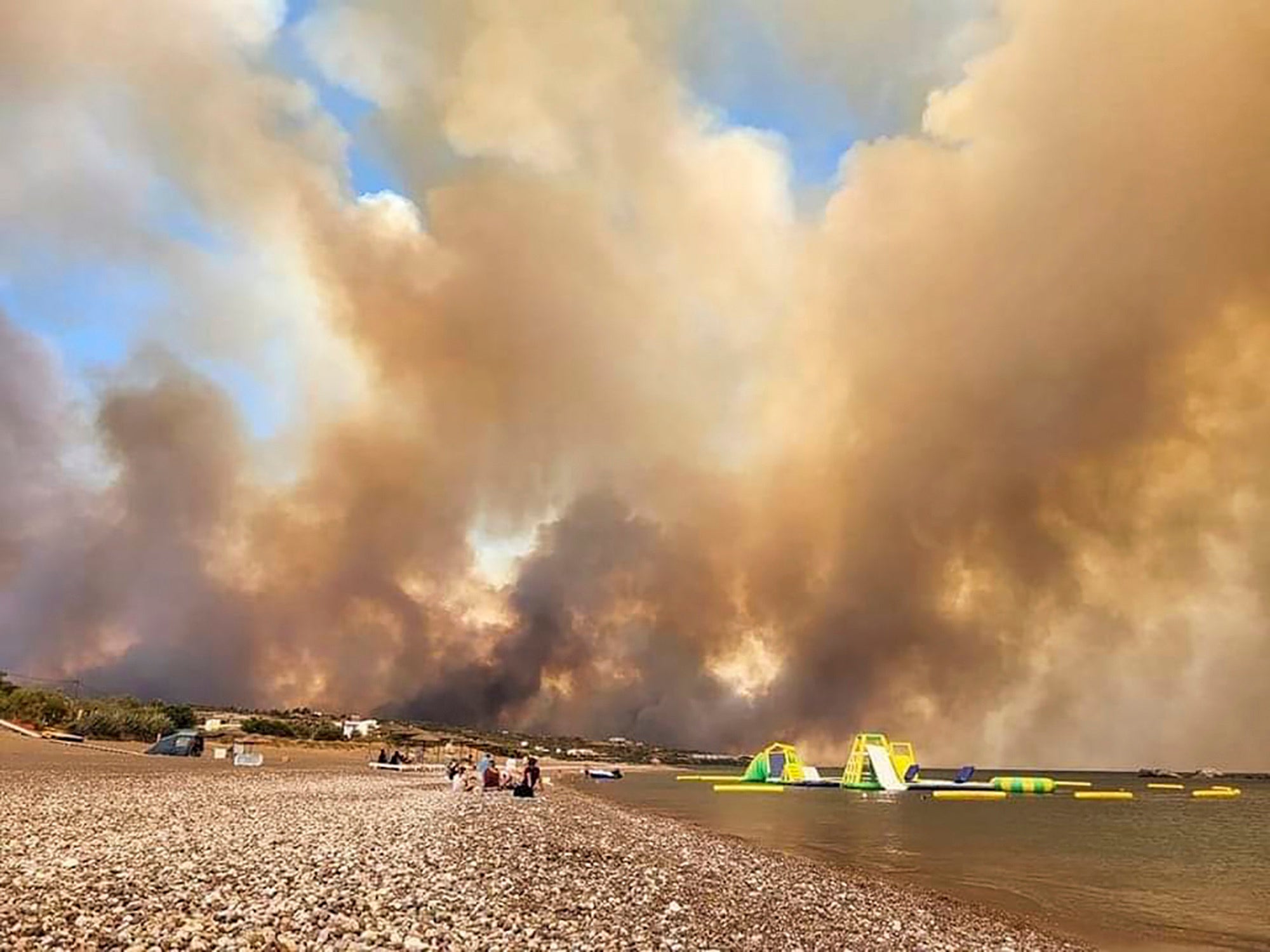 Clouds of smoke from a forest fire rise to the sky on the island of Rhodes, Greece