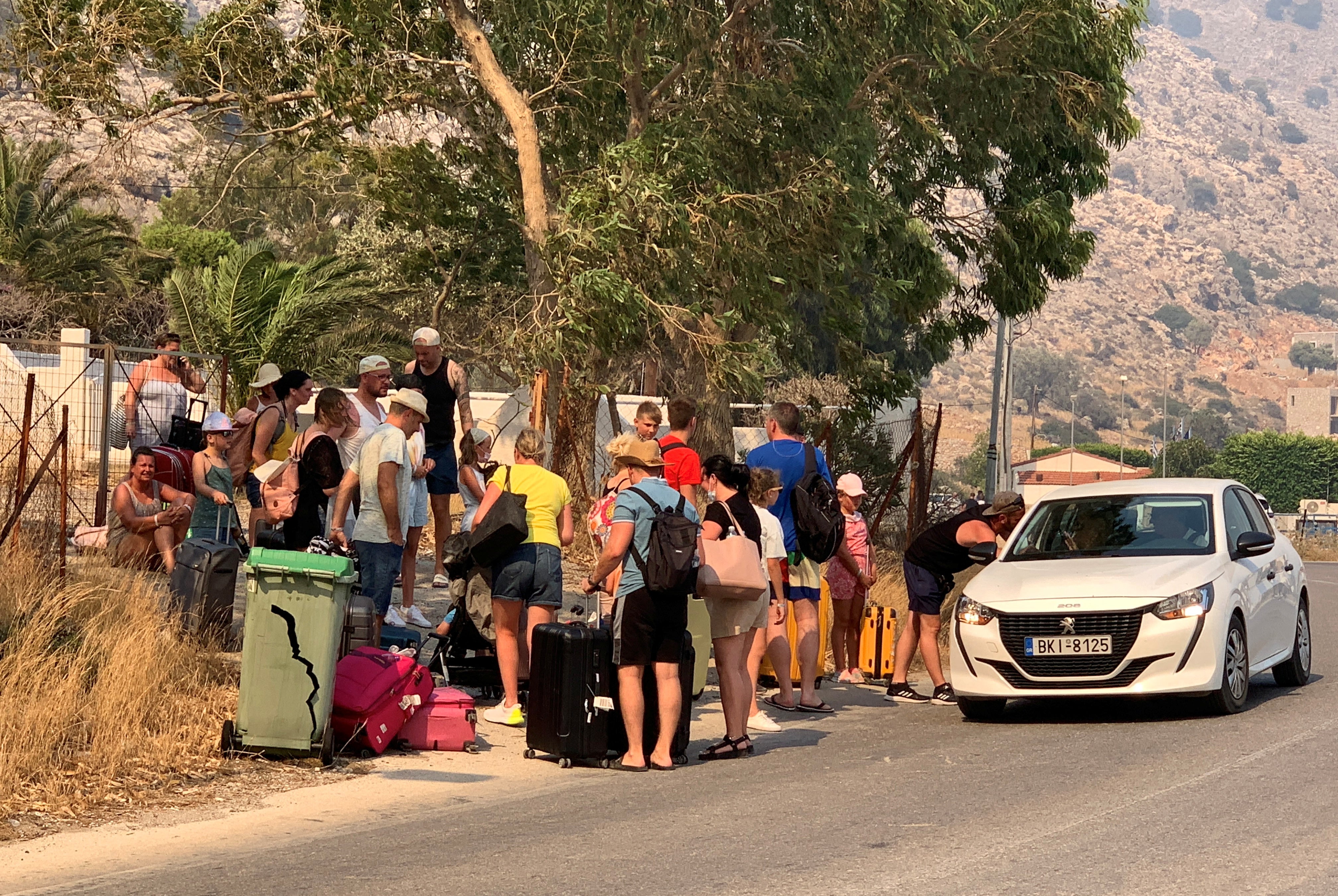 Tourists are being evacuated as wildfire burns near Lindos, on the island of Rhodes