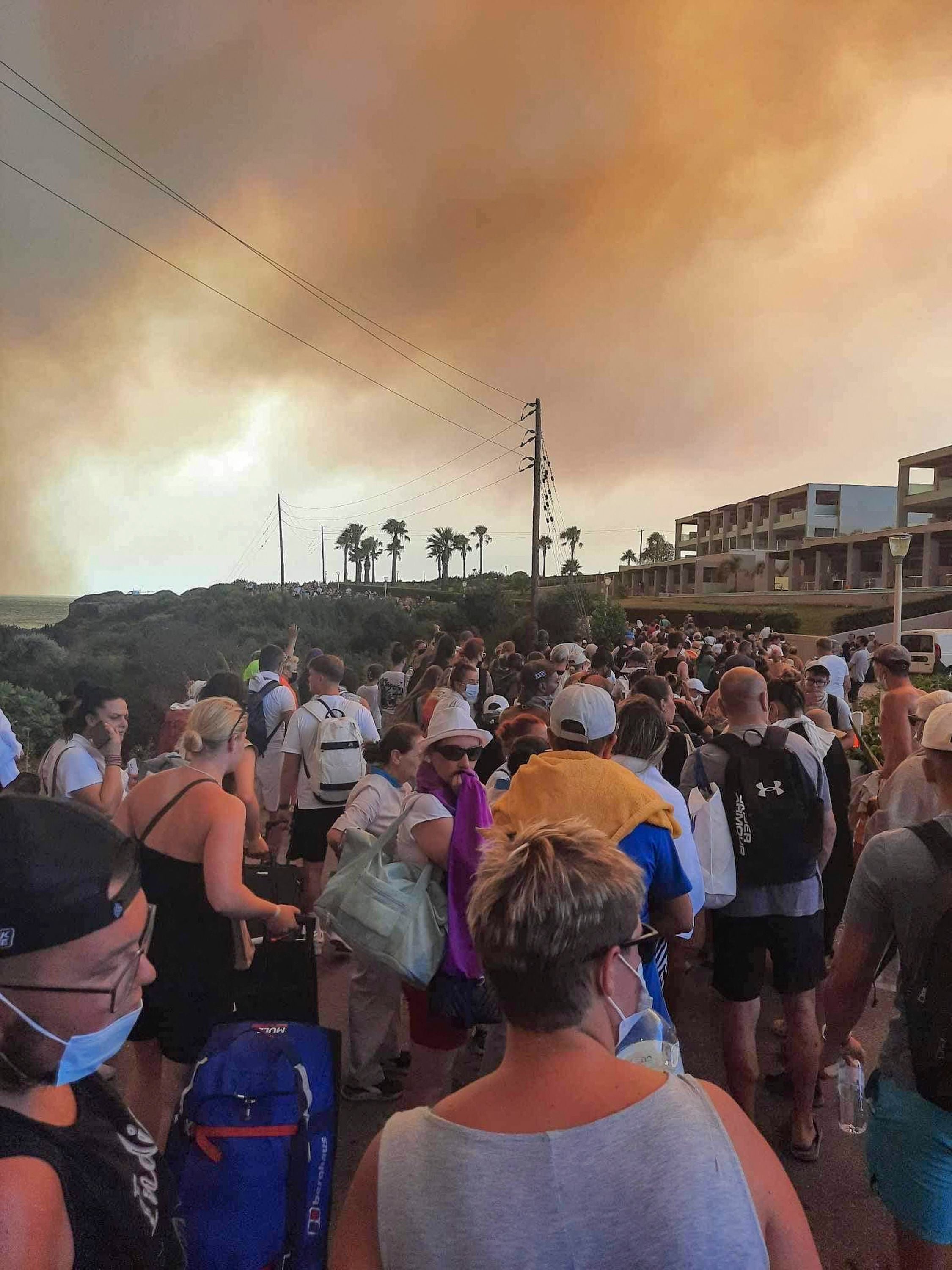 Tourists are evacuated from hotels during a wildfire on Rhodes on July 22