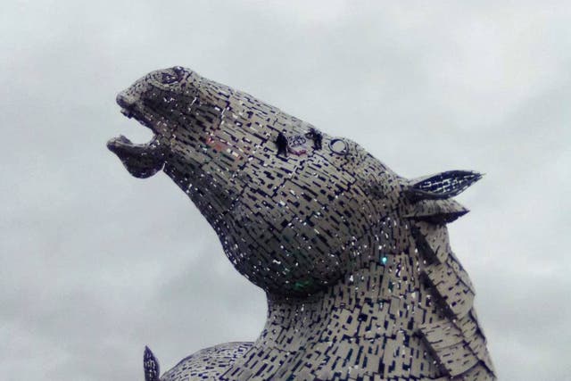 Activists scale The Kelpies statue between Falkirk and Grangemouth (This Is Rigged/PA)
