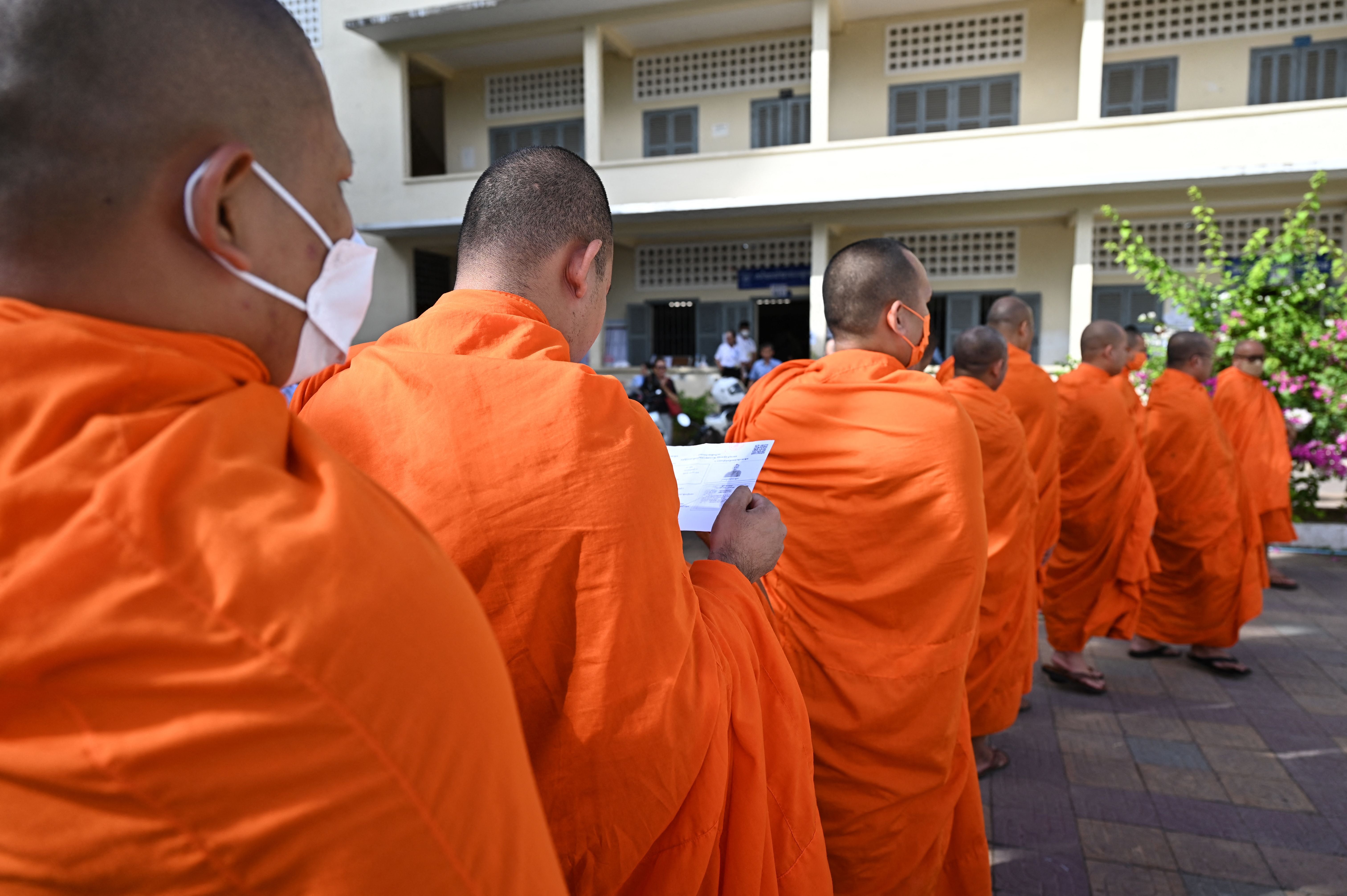 Buddhist monks line up to cast their votes at a polling station in Phnom Penh on 23 July, 2023 during the general elections