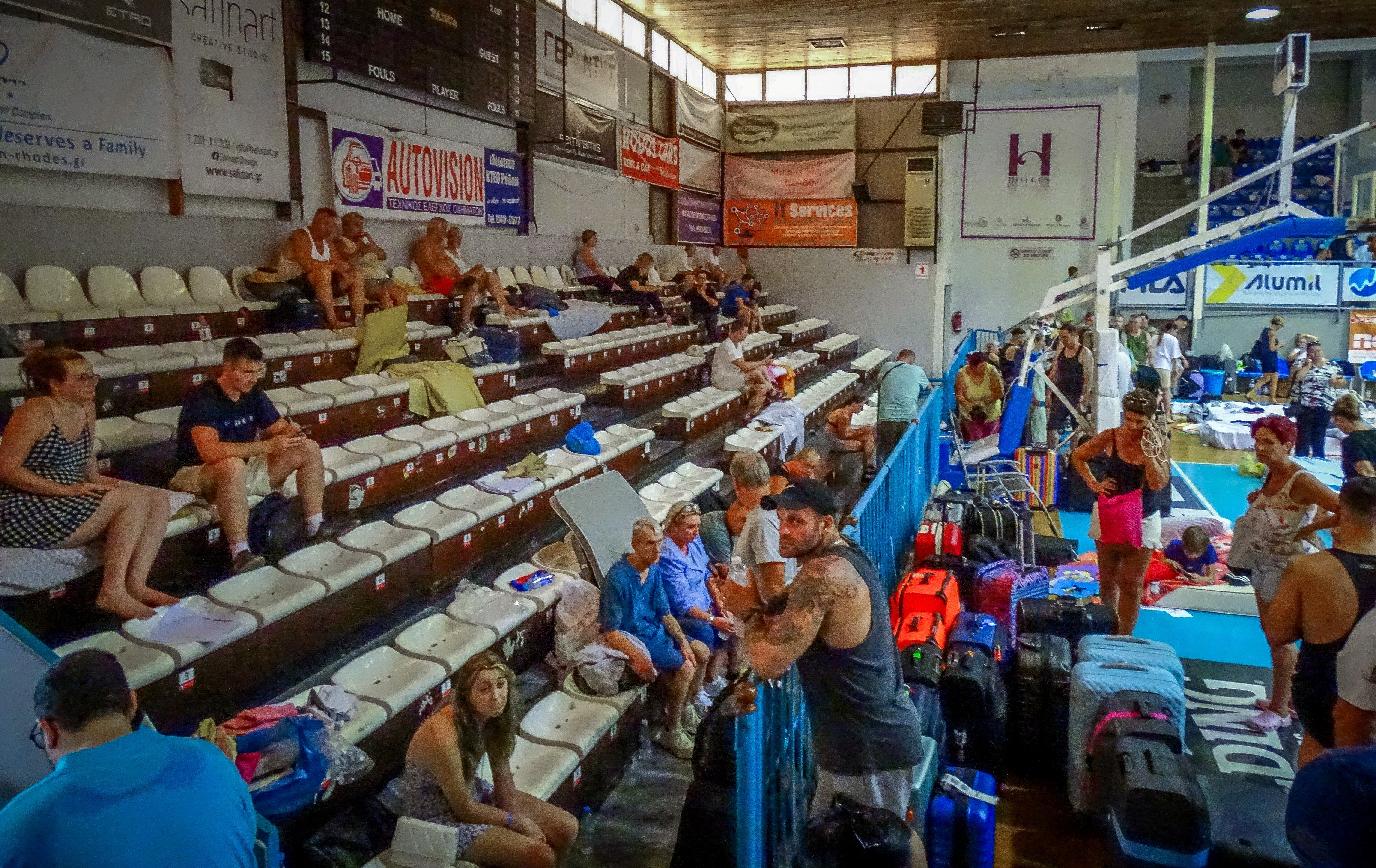 Tourists are sheltered in a stadium after being evacuated following a wildfire on the island of Rhodes, Greece