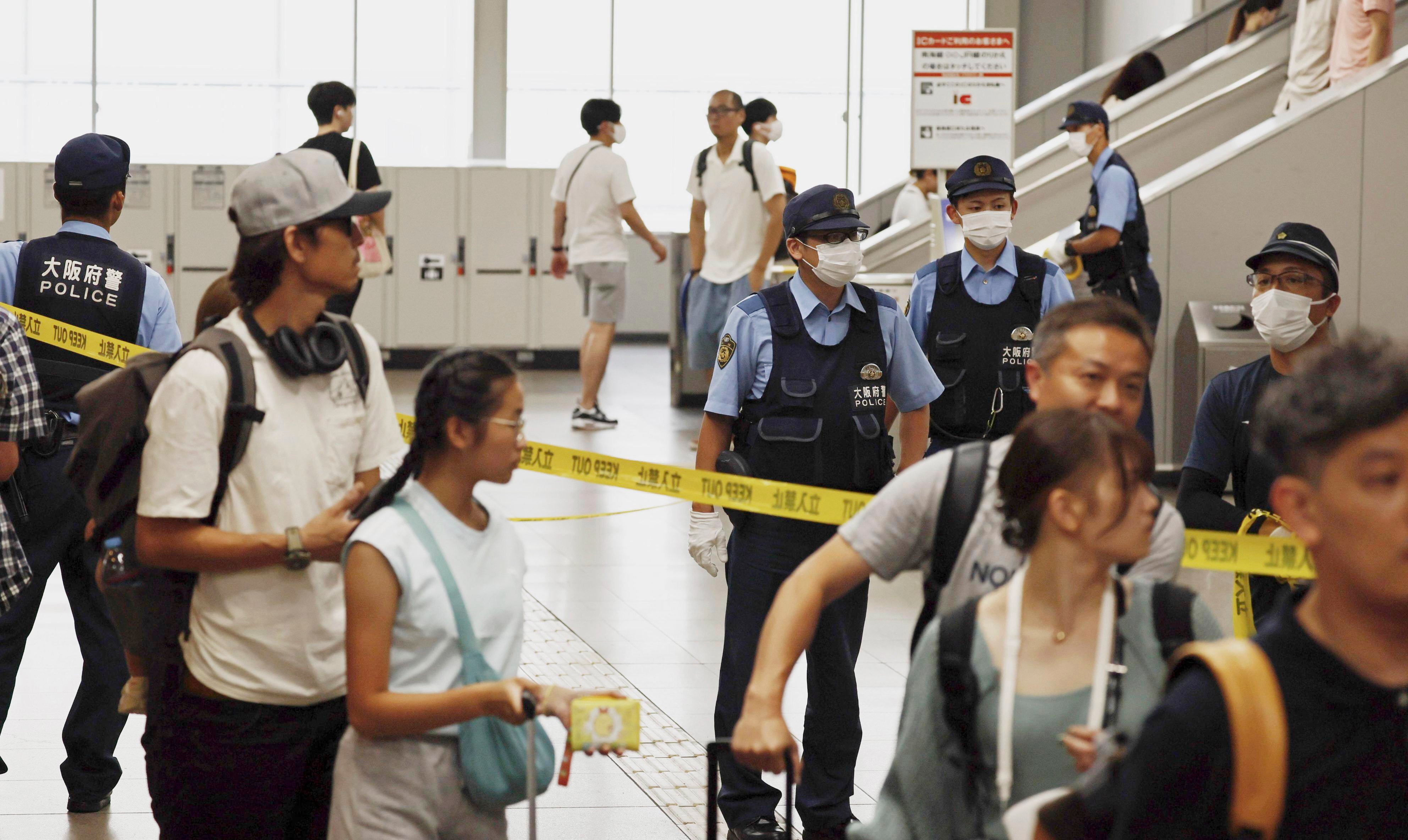 Japanese police officers patrol a train station after a man was arrested at the station in Izumisano, south of Osaka