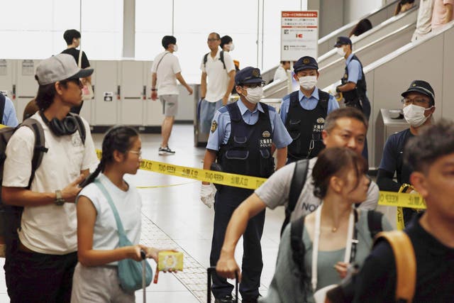 <p>Japanese police officers patrol a train station after a man was arrested at the station in Izumisano, south of Osaka</p>