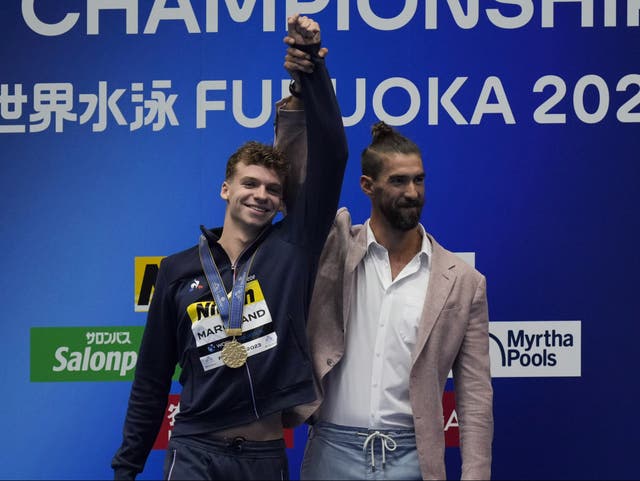 <p>Michael Phelps presented Leon Marchand with his gold medal </p>