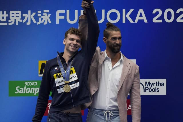 <p>Michael Phelps presented Leon Marchand with his gold medal </p>
