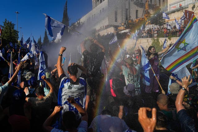 <p>Israeli police use a water cannon to disperse demonstrators blocking a Jerusalem road in protest at the judicial reforms on Monday </p>