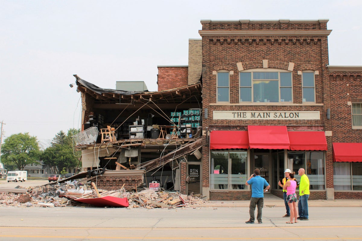 Minivan strikes building, leaving roof sagging and turning much of its facade to pile of bricks