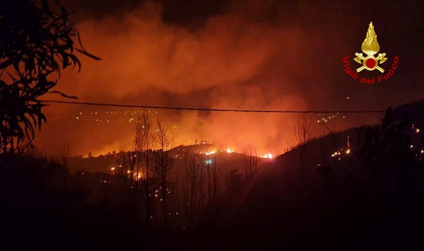 Flames and smoke rise as a wildfire burns near the Sicilian village of Curcuraci near Messina, Italy