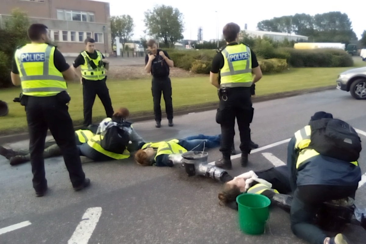 Climate protesters ‘concrete’ themselves to road to block refinery