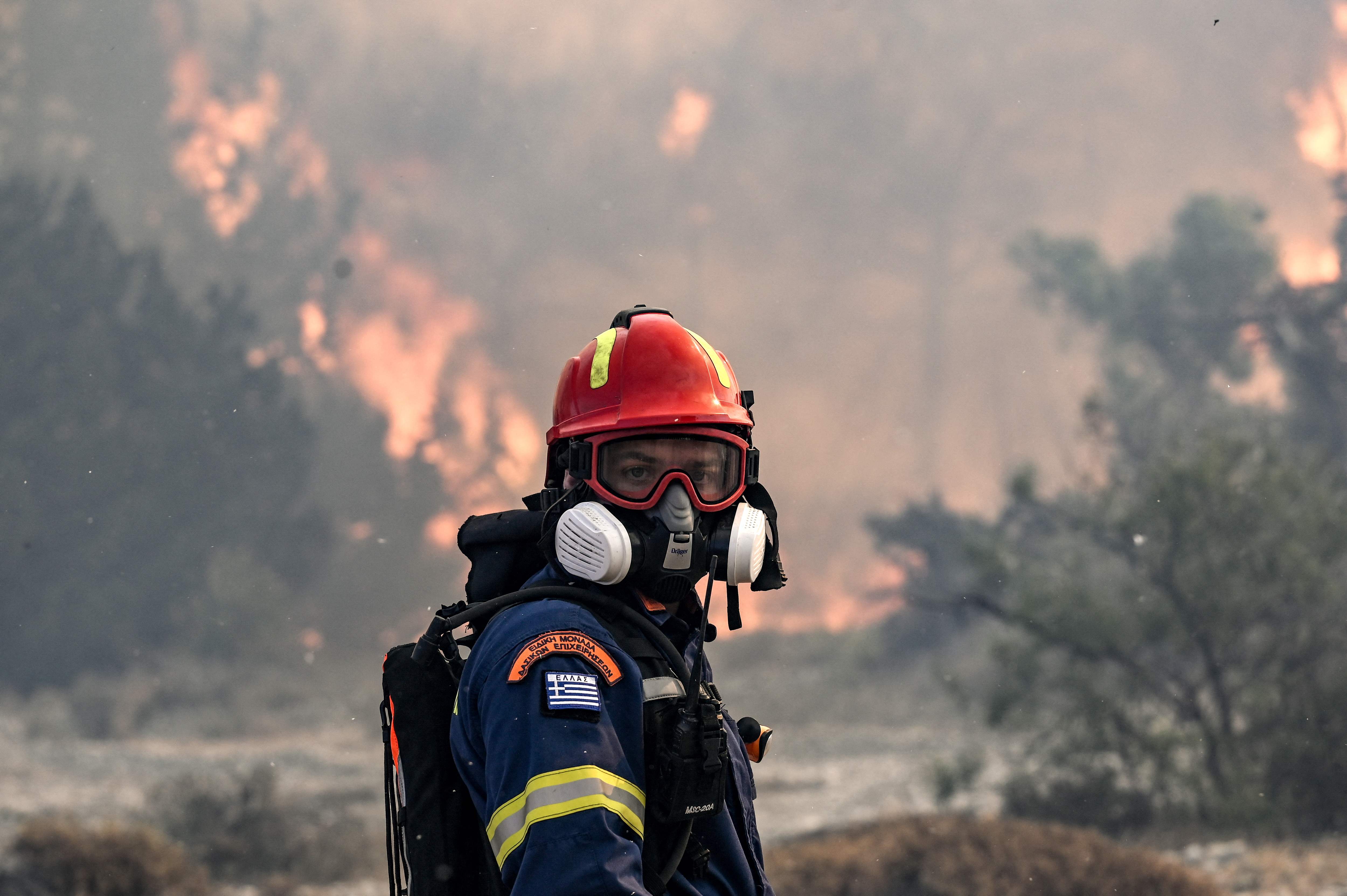 A firefighter looks on during a fire near the village of Vati, just north of the coastal town of Gennadi, in the southern part of Rhodes, Greece
