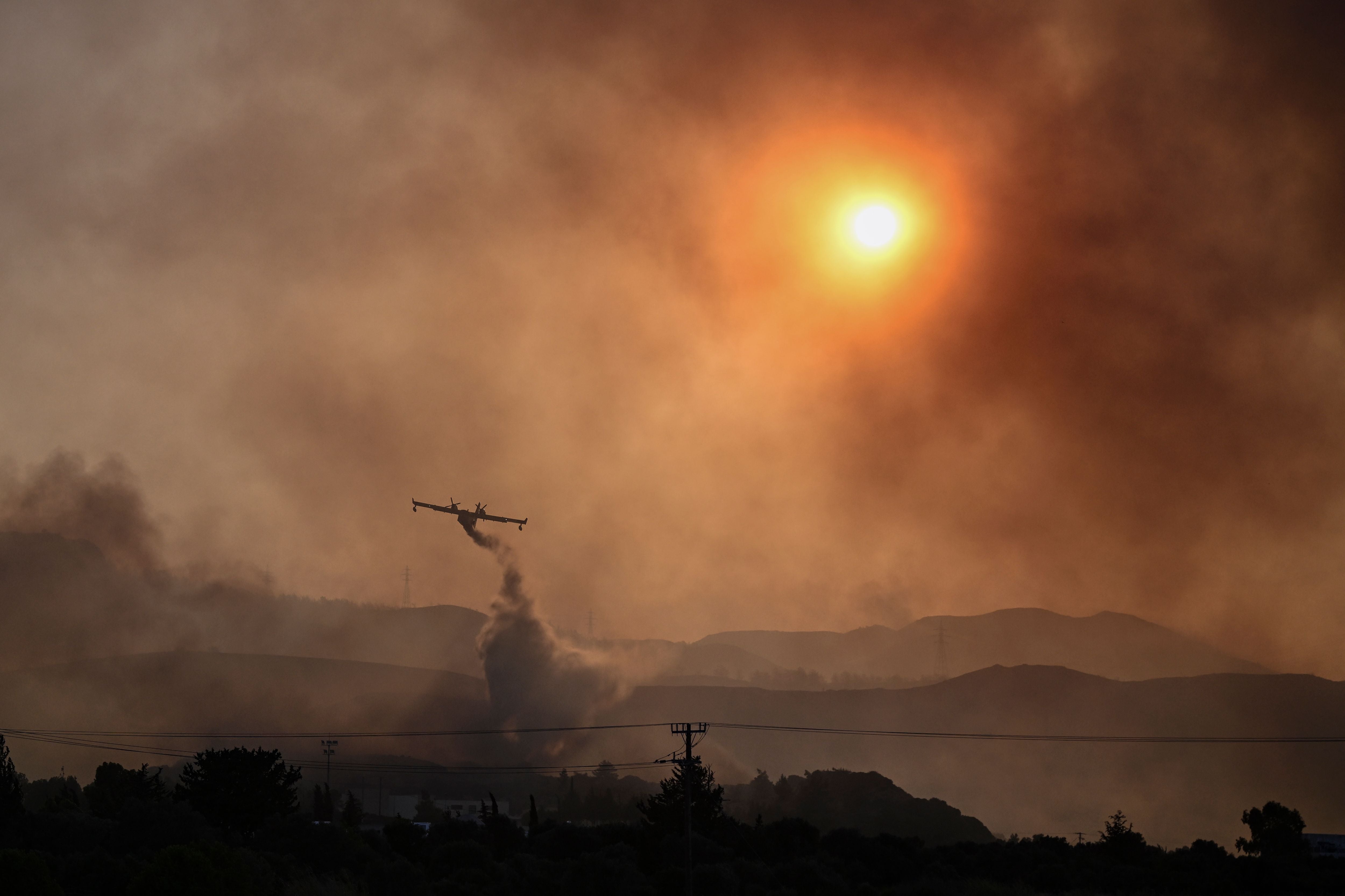 <p>A Canadair firefighting airplane sprays water on a fire in the southern part of the Greek island of Rhodes</p>