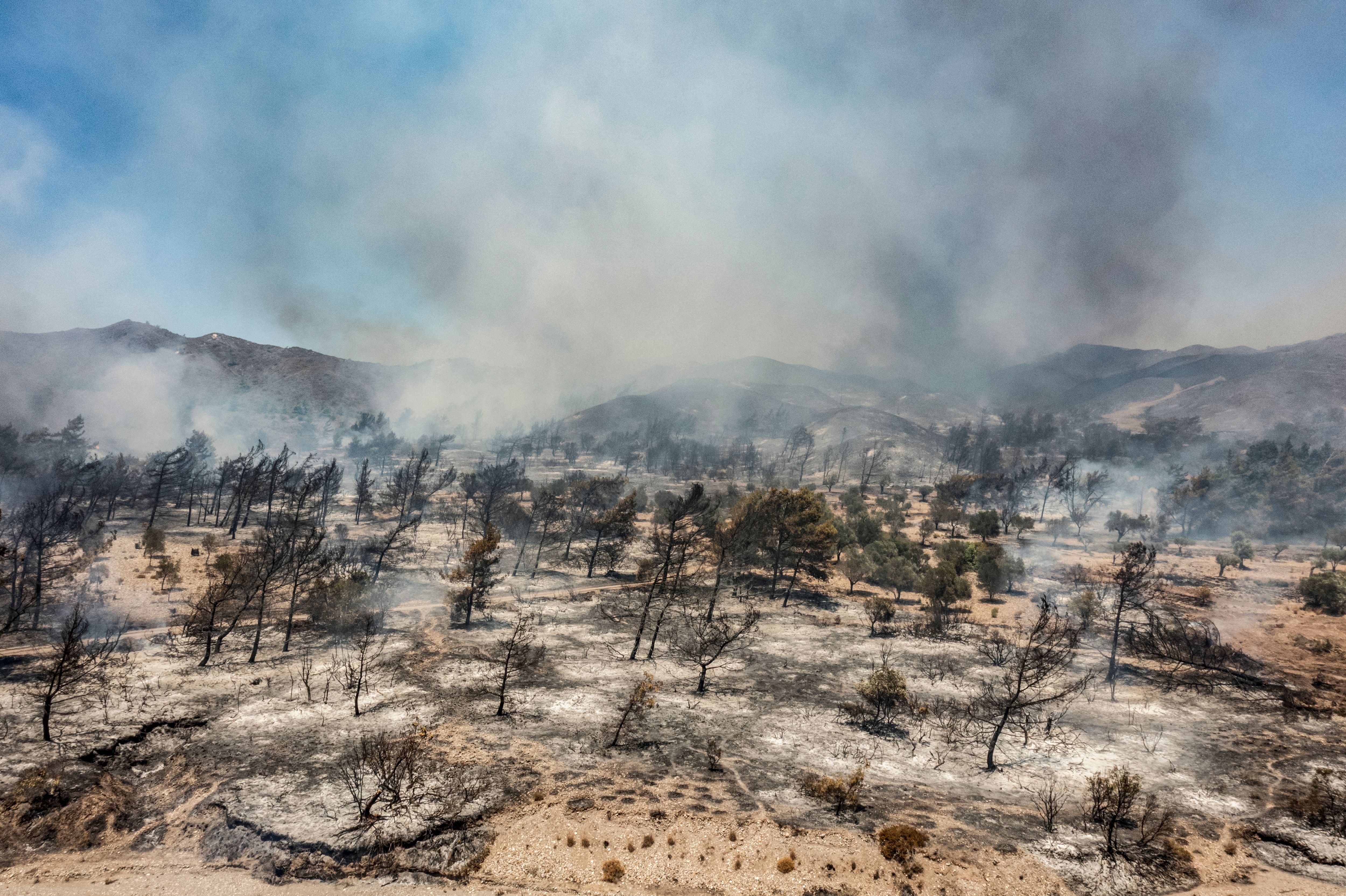 An aerial view shows wildfires burning a forest near Vati