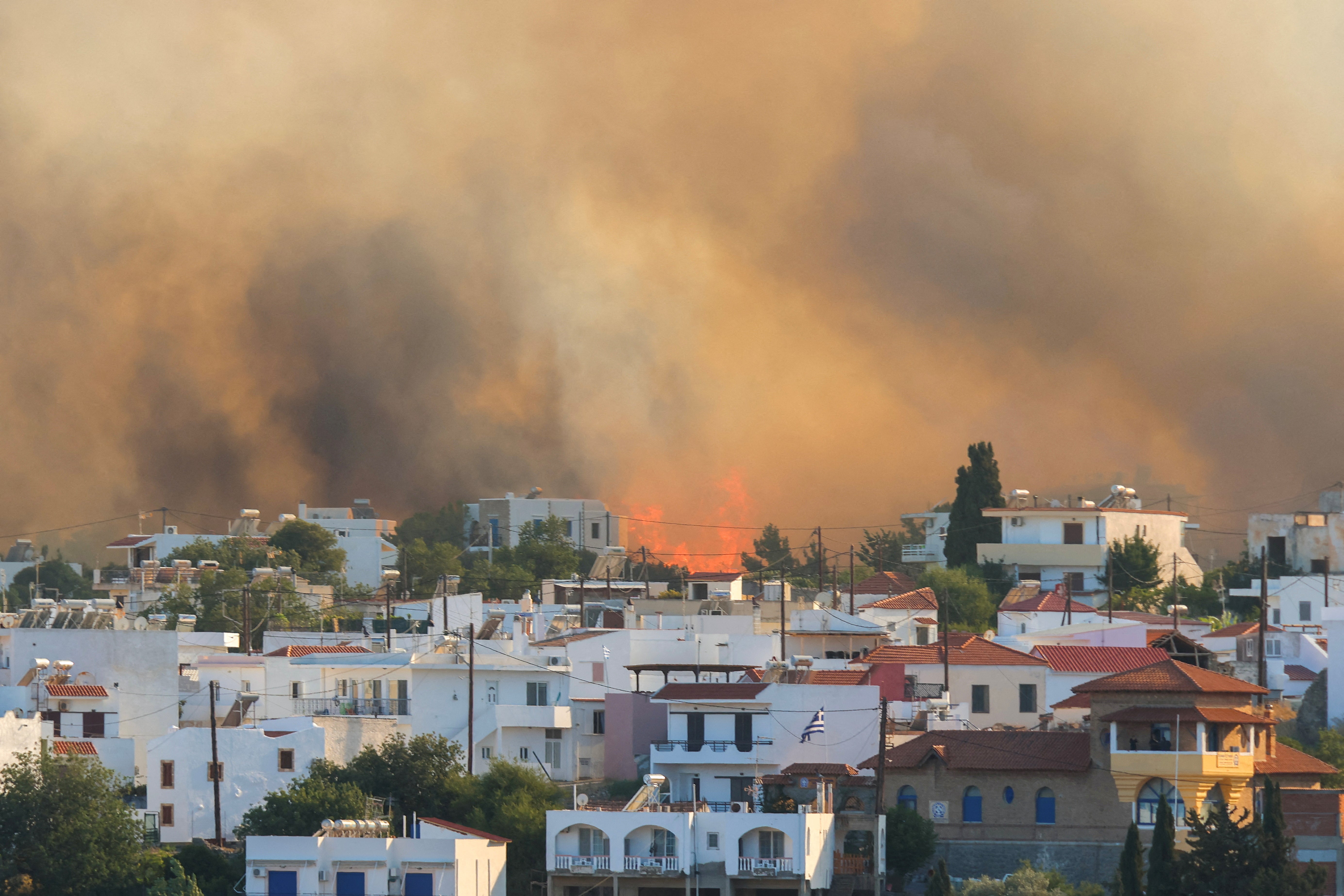 Flames and smoke rise as a wildfire burns near the village of Gennadi, on the island of Rhodes, Greece
