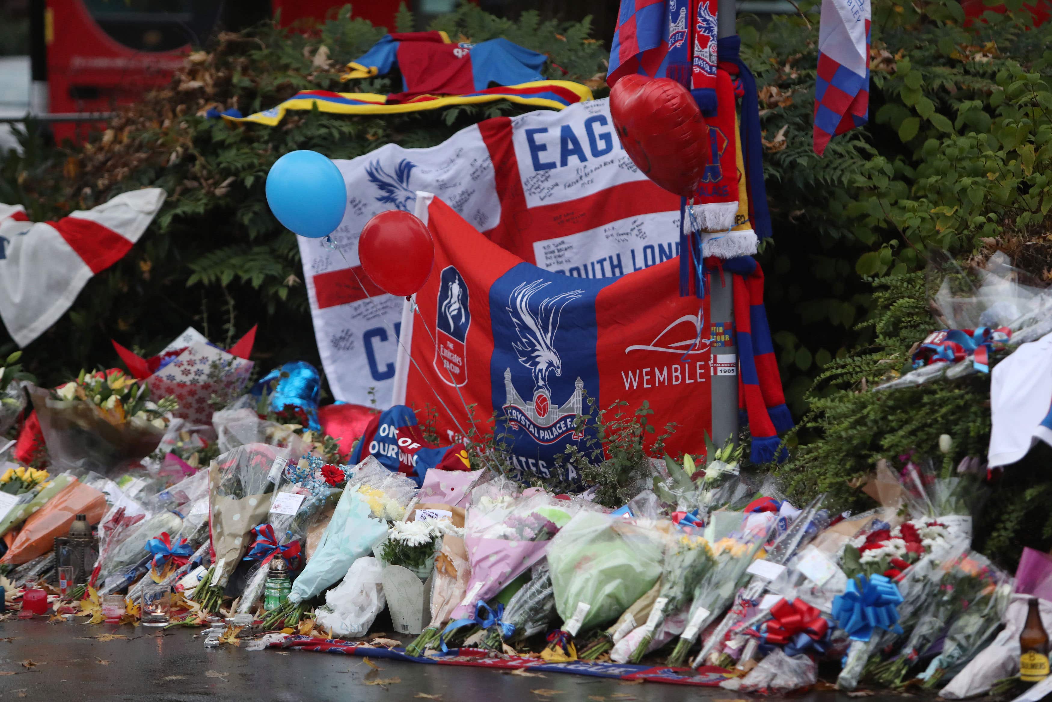 Floral tributes and Crystal Palace football colours left near the scene where a tram crashed, killing seven people, in Croydon, south London (PA)