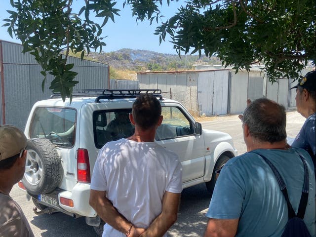 <p>Volunteers watch on as a flare-up reignites near Malonas</p>