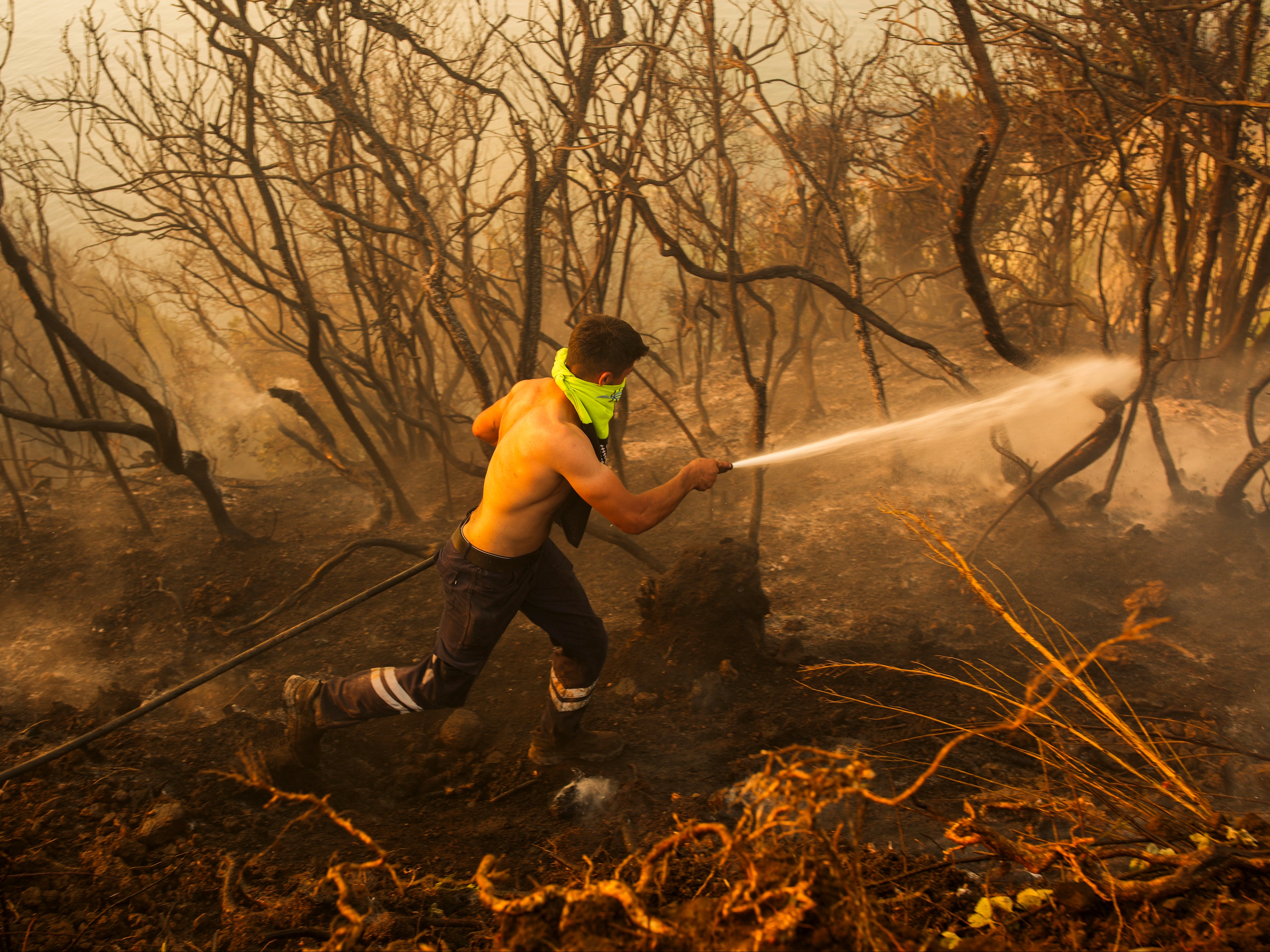 A Turkish firefighter works to extinguish a forest wildfire in Beykoz, on the outskirts of Istanbul