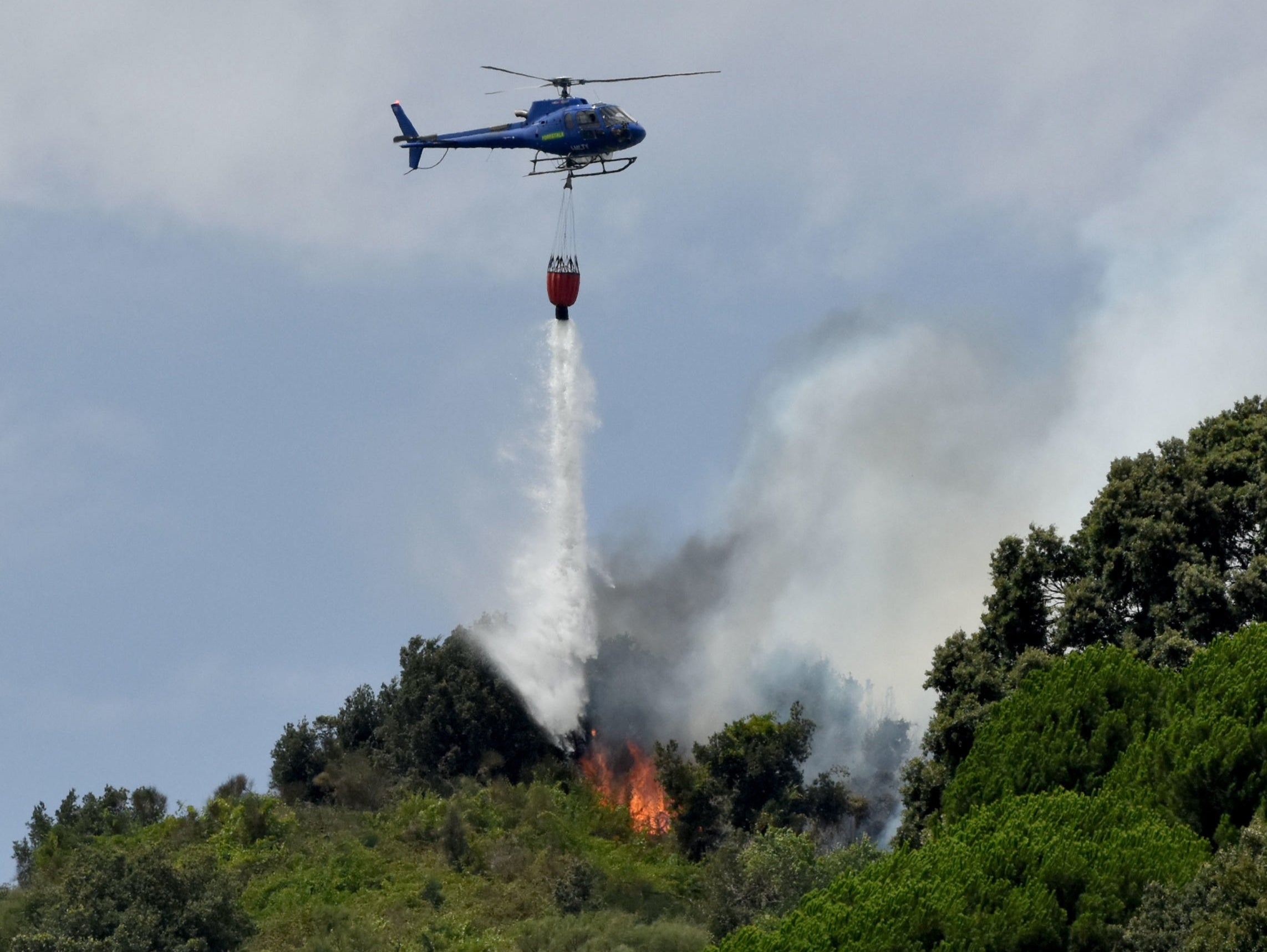 A helicopter douses flames in Italy