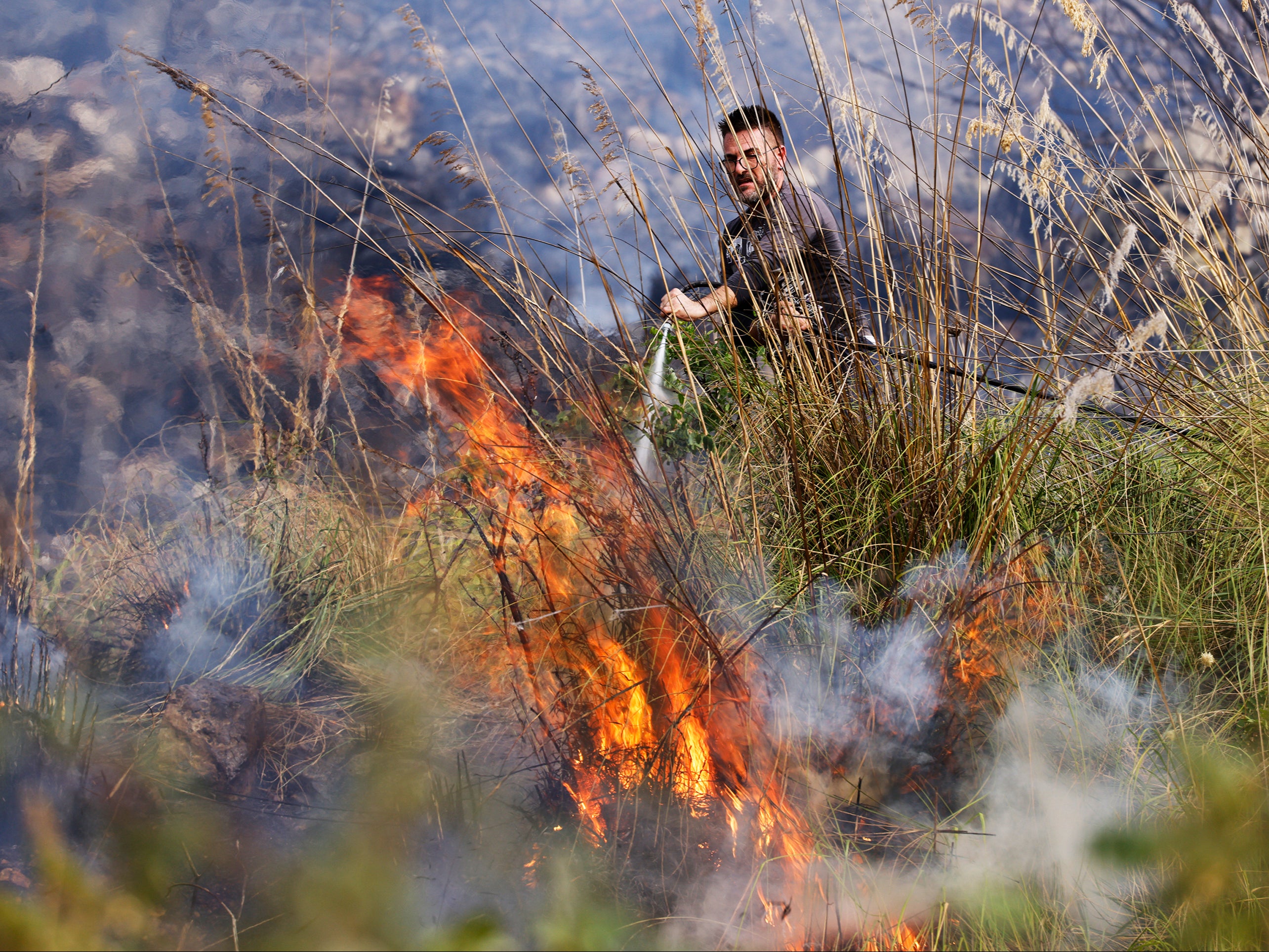 A fire team puts out flames in Capaci, near Palermo, Sicily